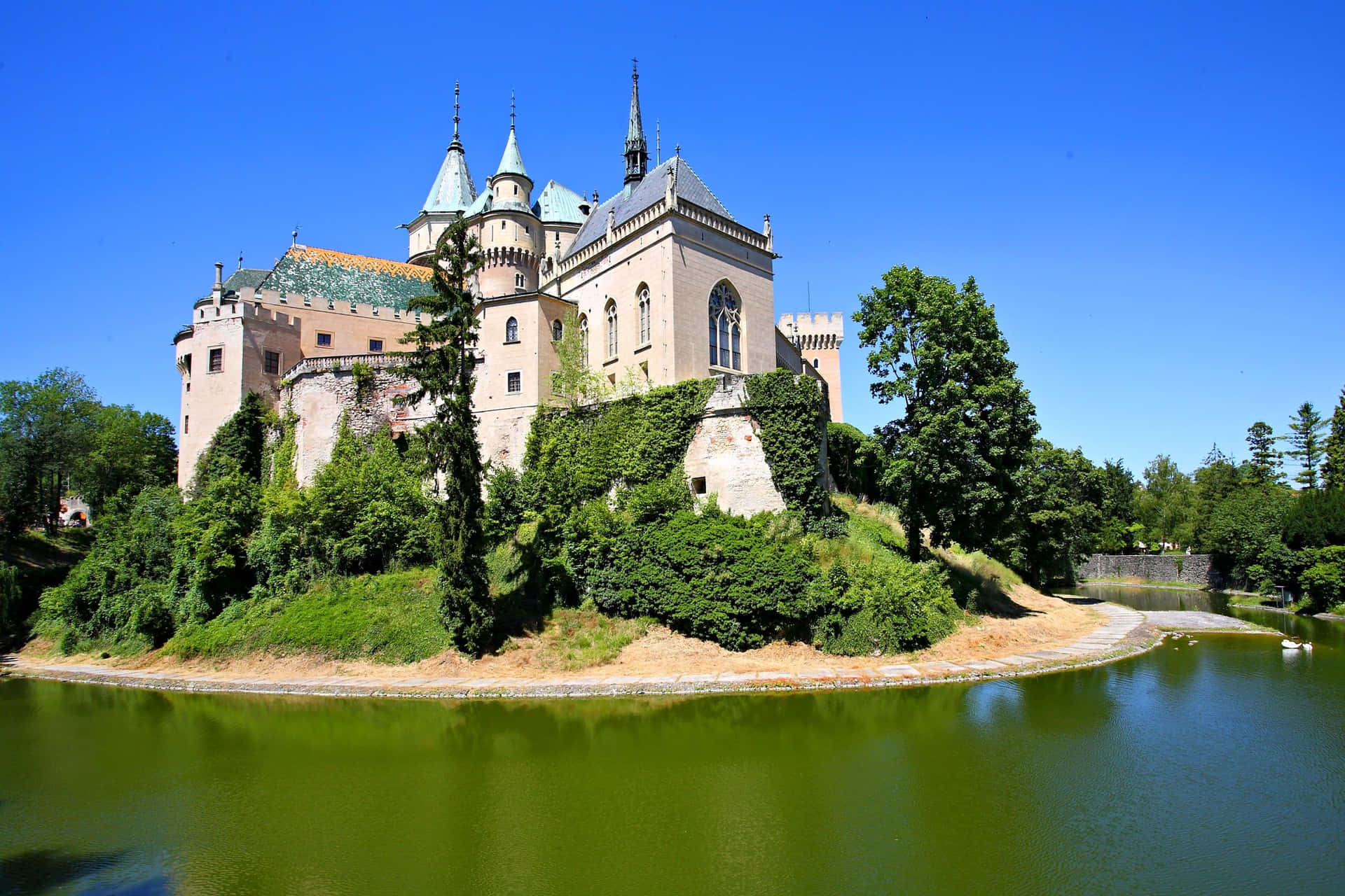 Captivating View of Bojnice Castle Surrounded by Water Wallpaper
