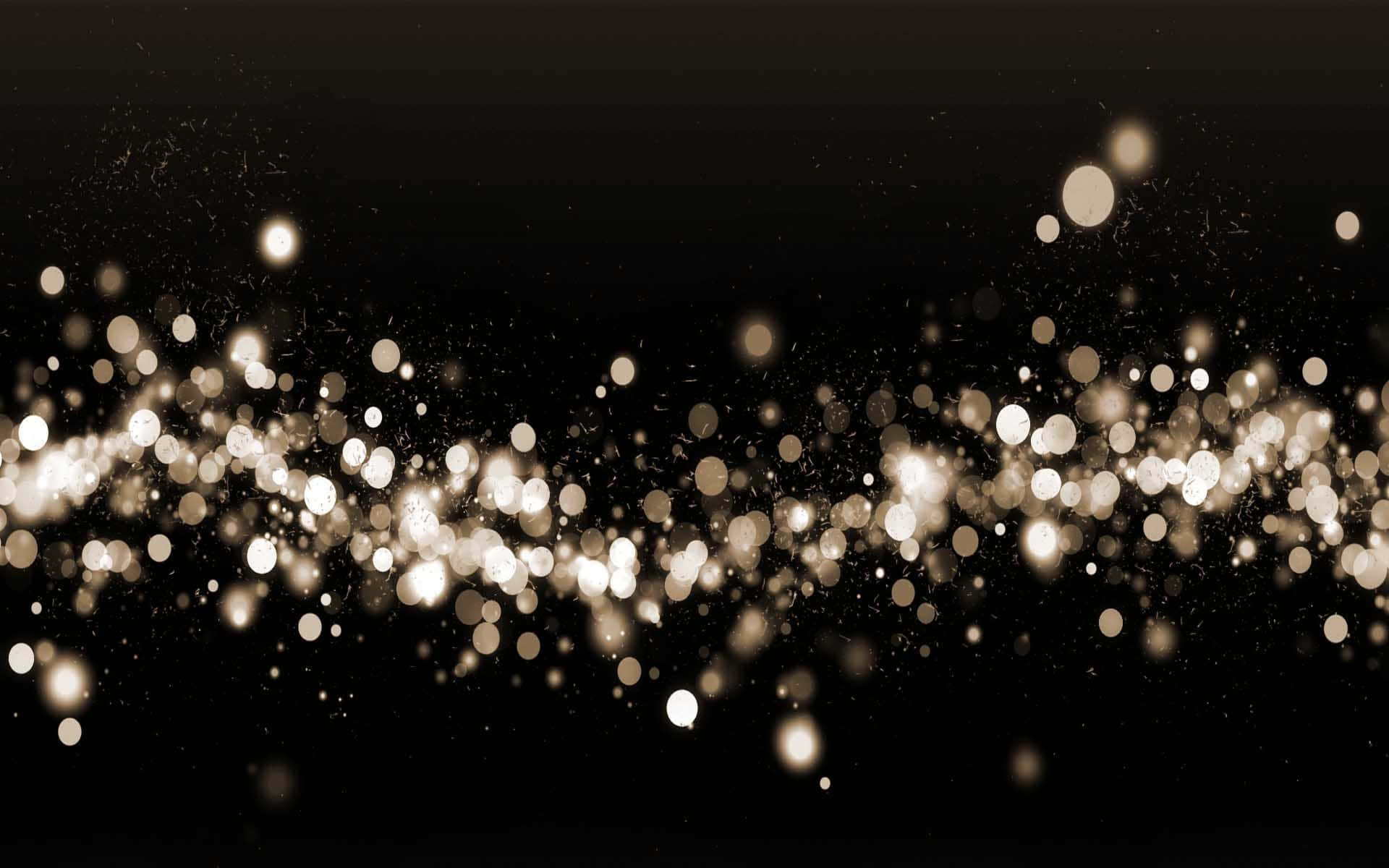 A Black Background With Gold Lights And Sparkles