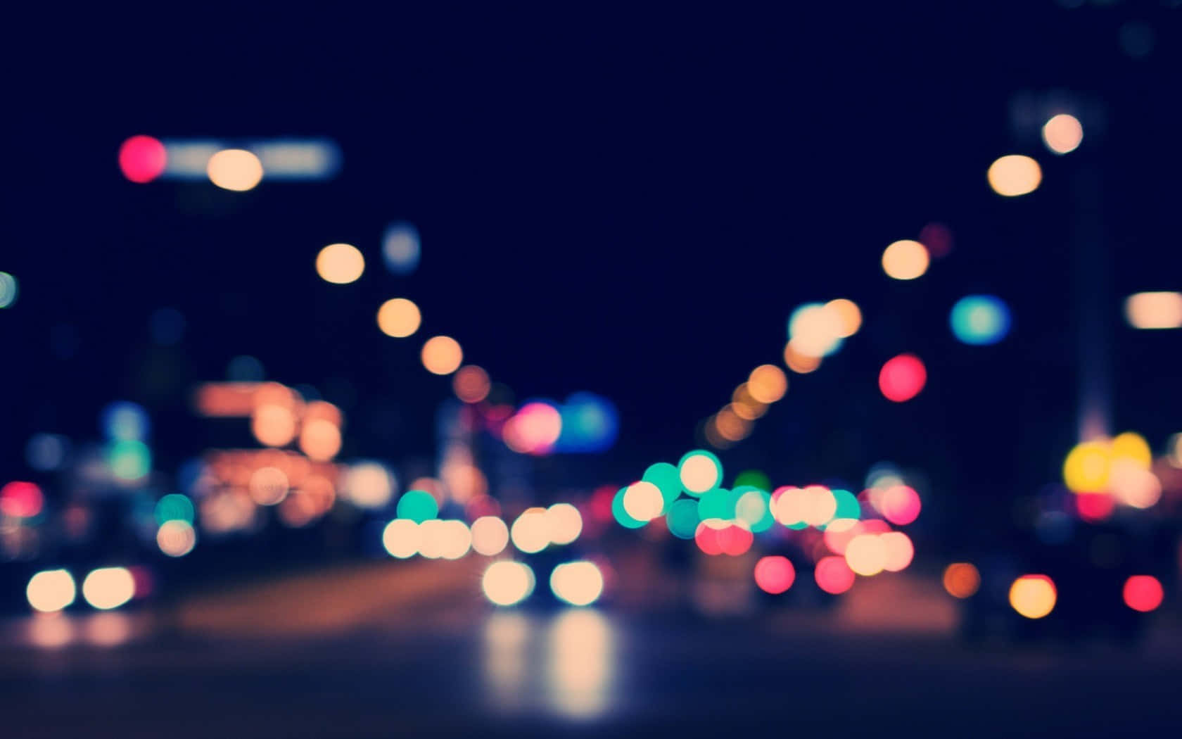 A Blurry Image Of A City Street At Night