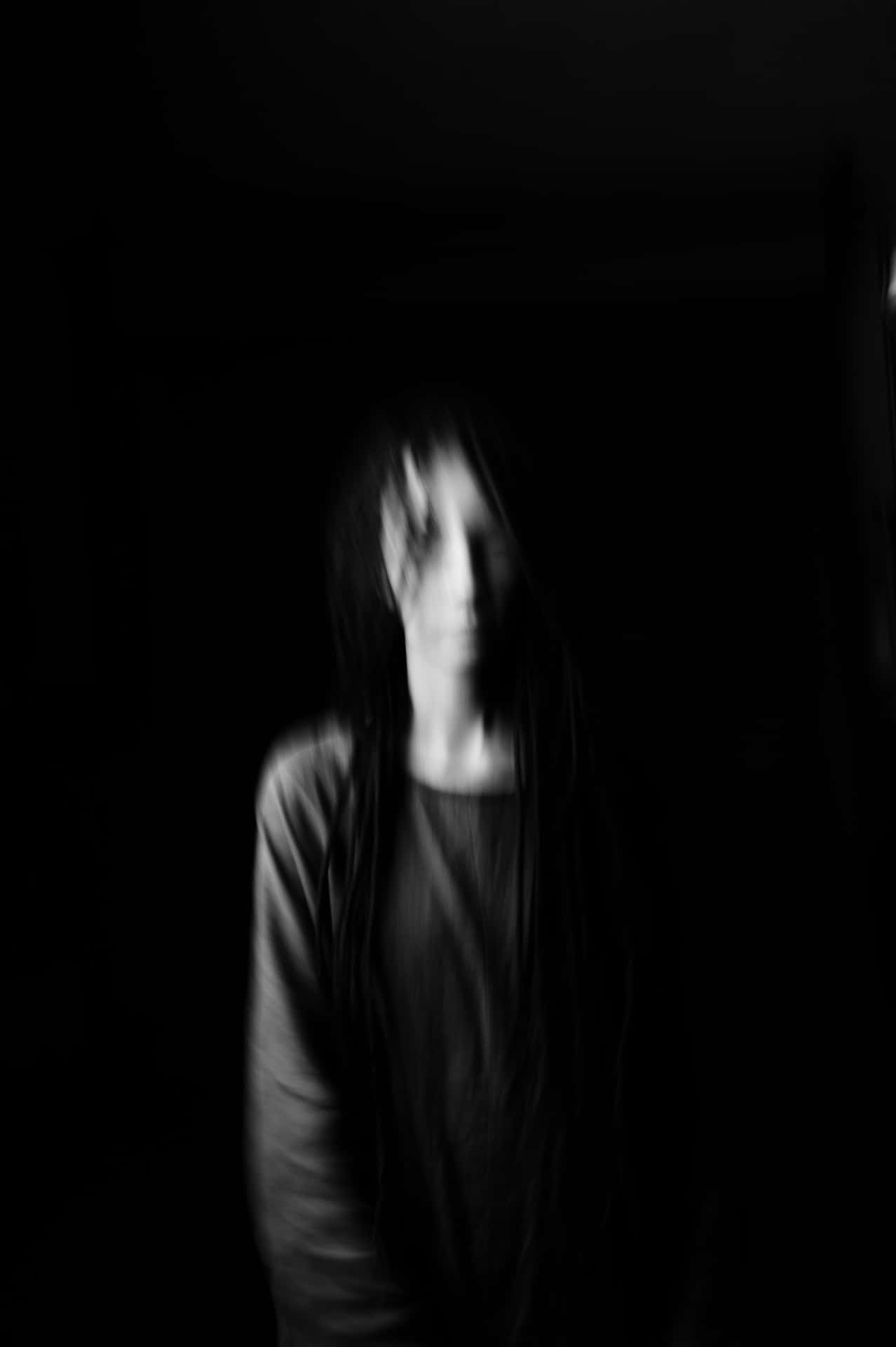 A Person With Dreadlocks Standing In The Dark Wallpaper