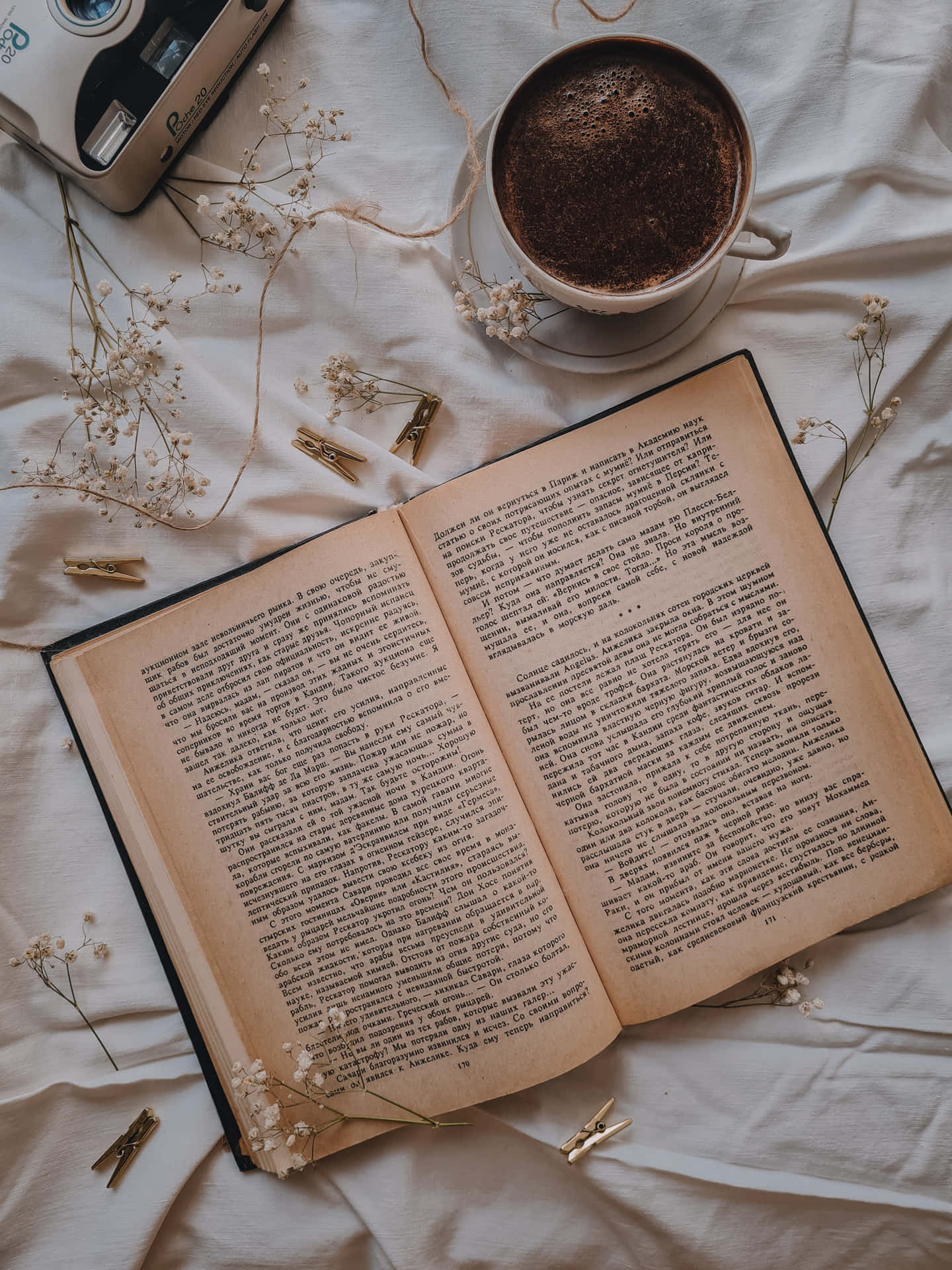A Book With Coffee And Flowers On A Bed