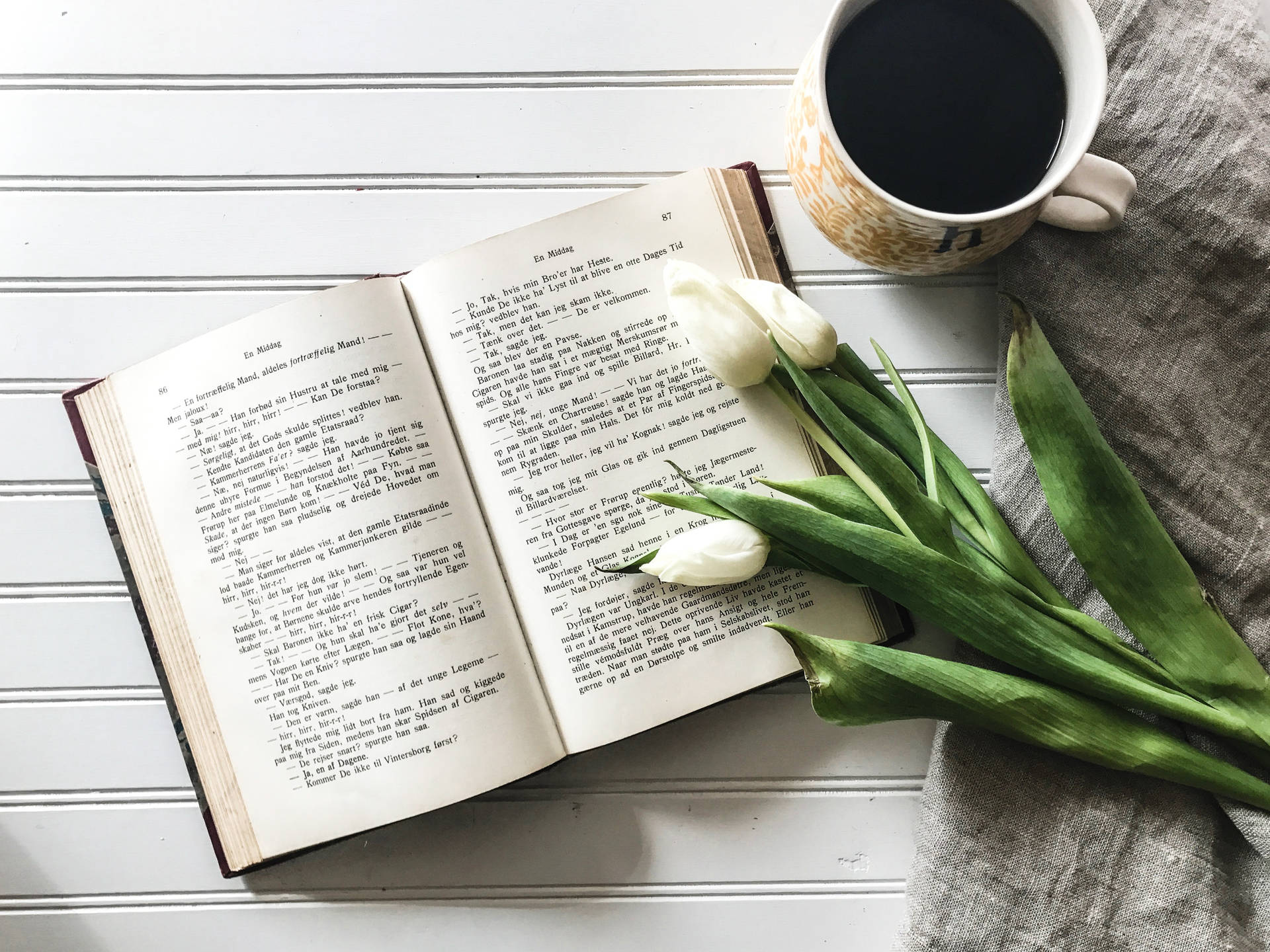 Book, tulips, and coffee on the table wallpaper