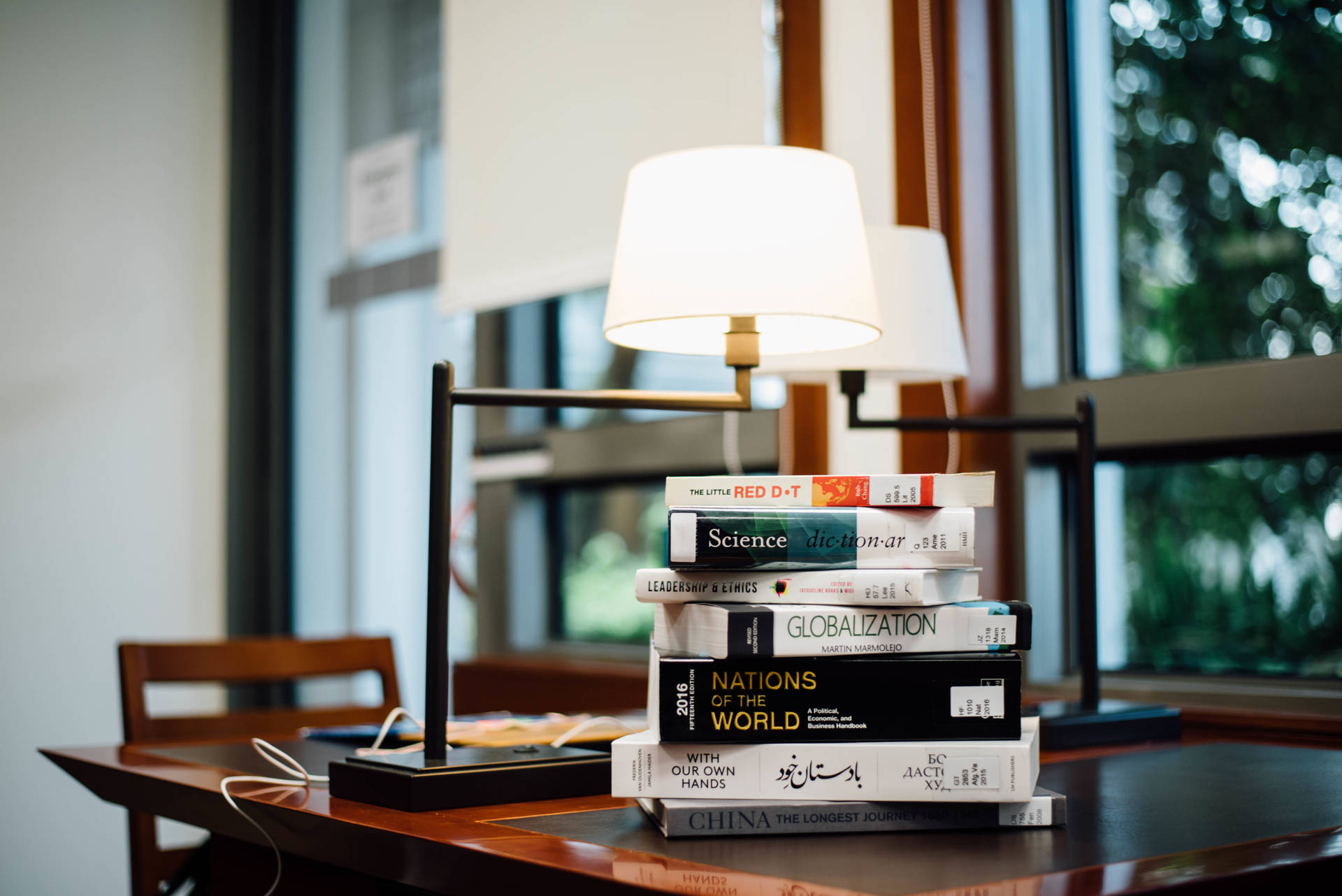 Books and a lamp on a table wallpaper