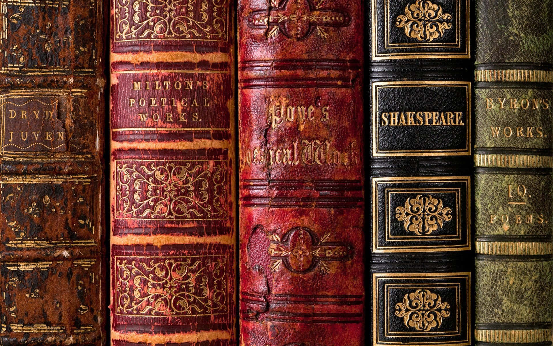 A Row Of Old Books With Gold And Silver Designs