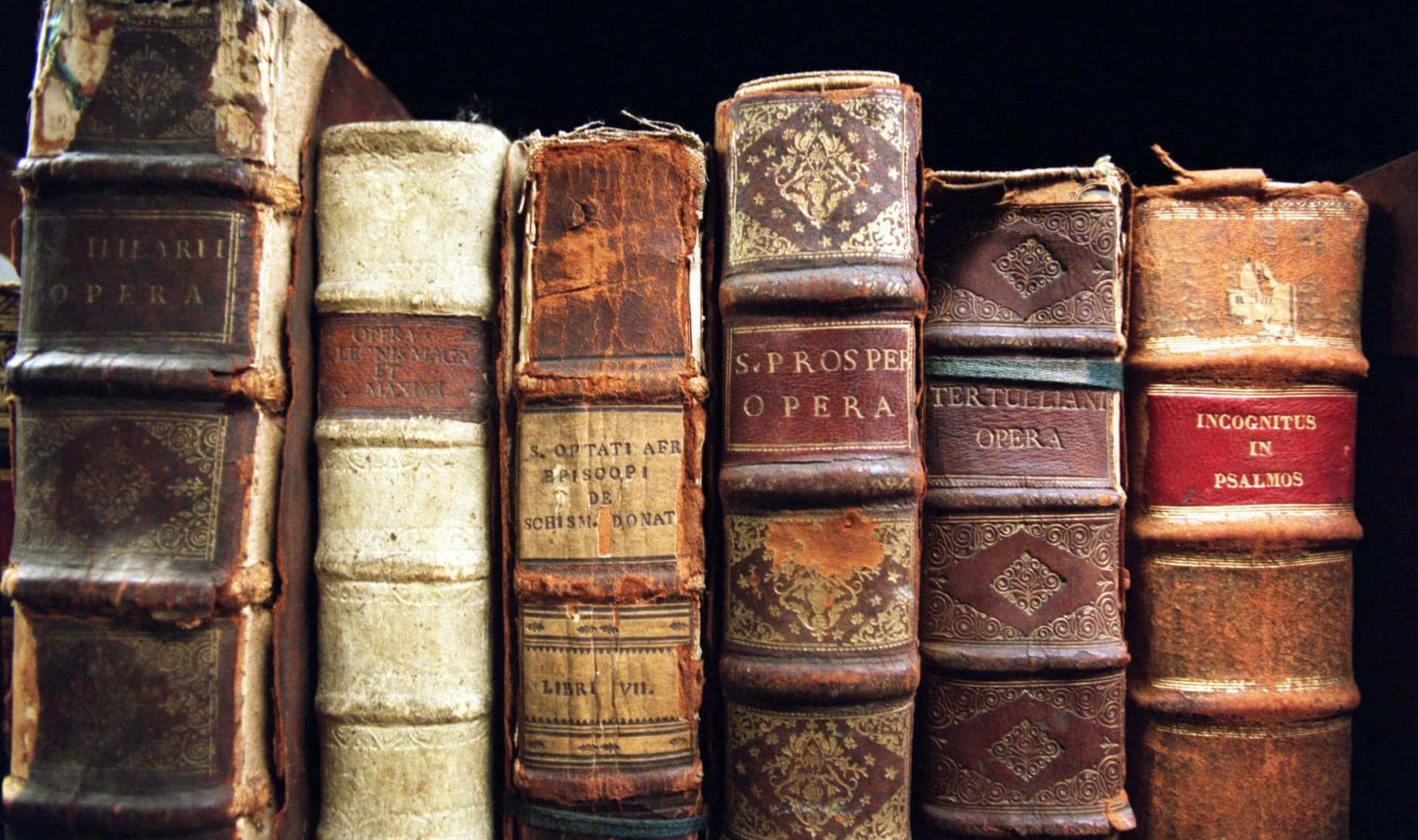 A Row Of Old Books On A Black Background