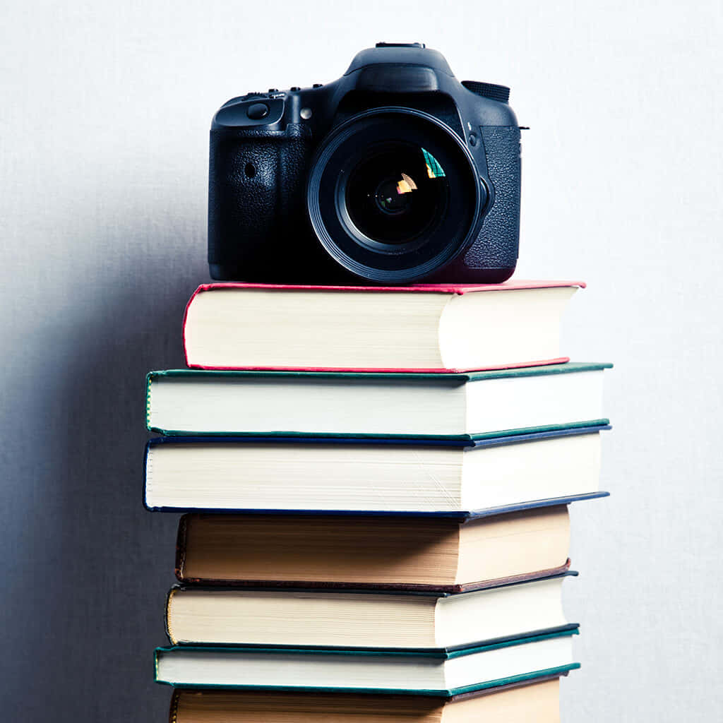 A Camera Sitting On Top Of A Stack Of Books