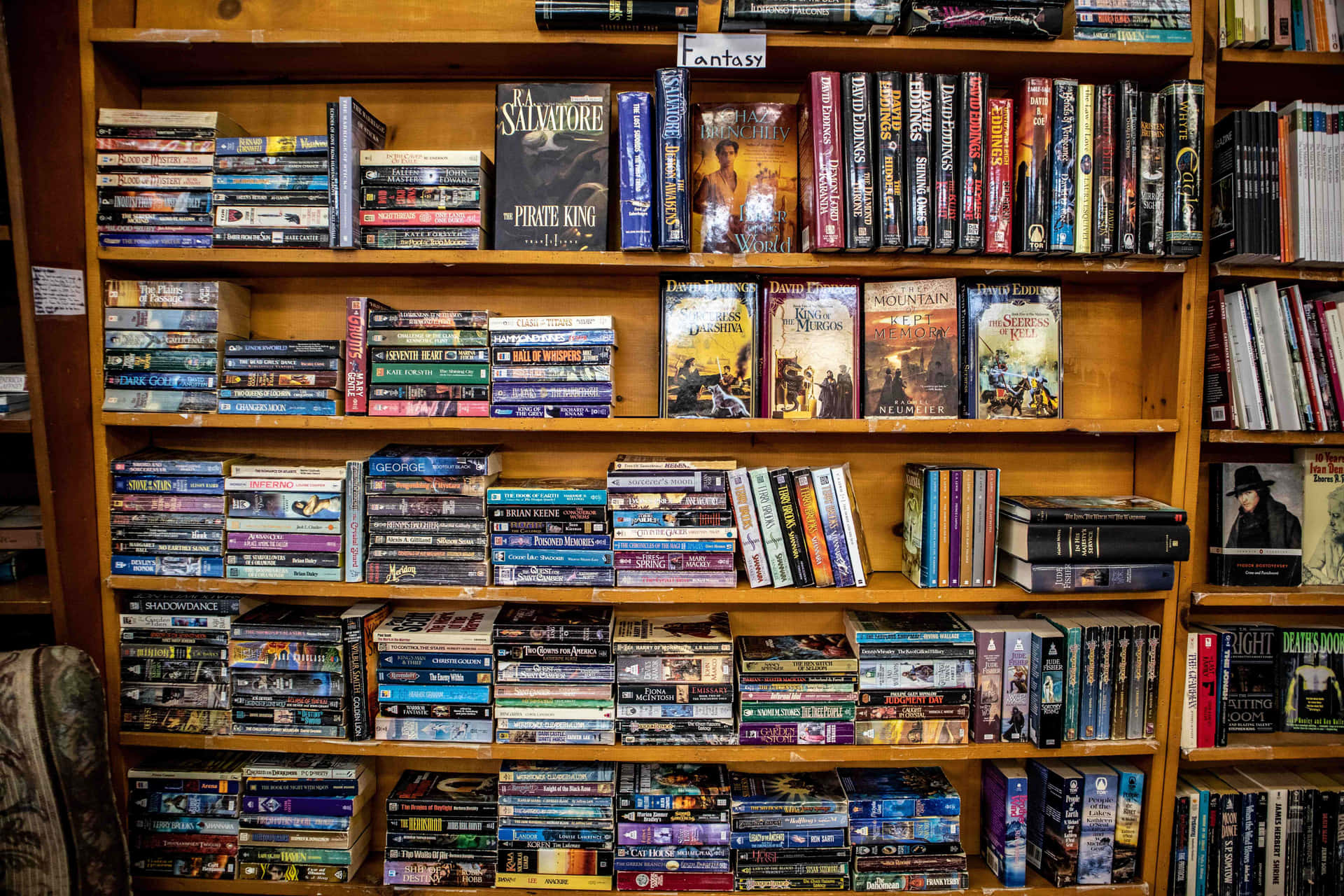 A bookshelf surrounded by a glass case and filled with books, perfect for a Zoom background