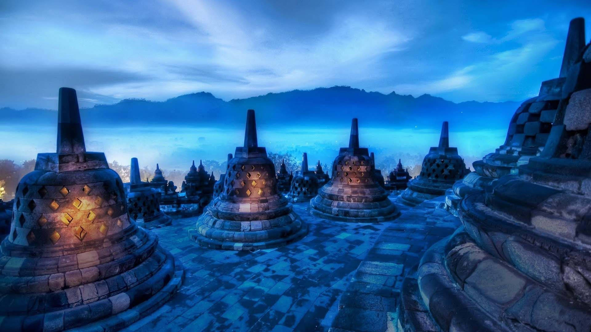 Borobudur Temple At Night With Fog And Mountains Wallpaper