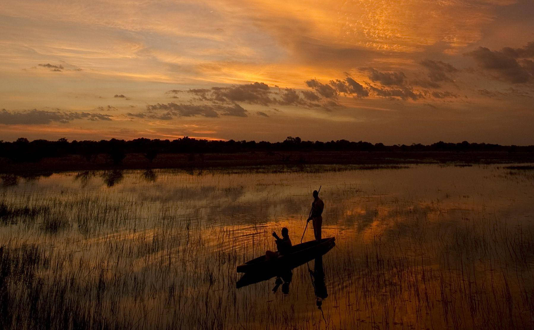Canoa Al Tramonto In Botswana Sfondo