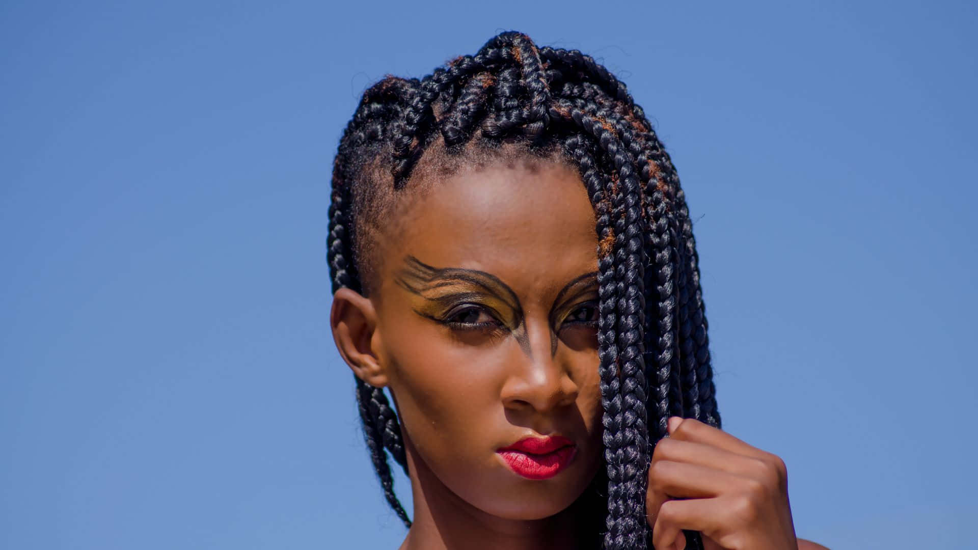 A Young Woman With Braids And Makeup