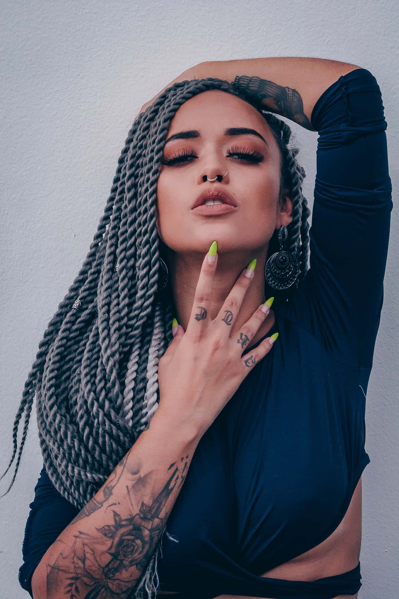 A Woman With Dreadlocks And A Tattoo On Her Arm
