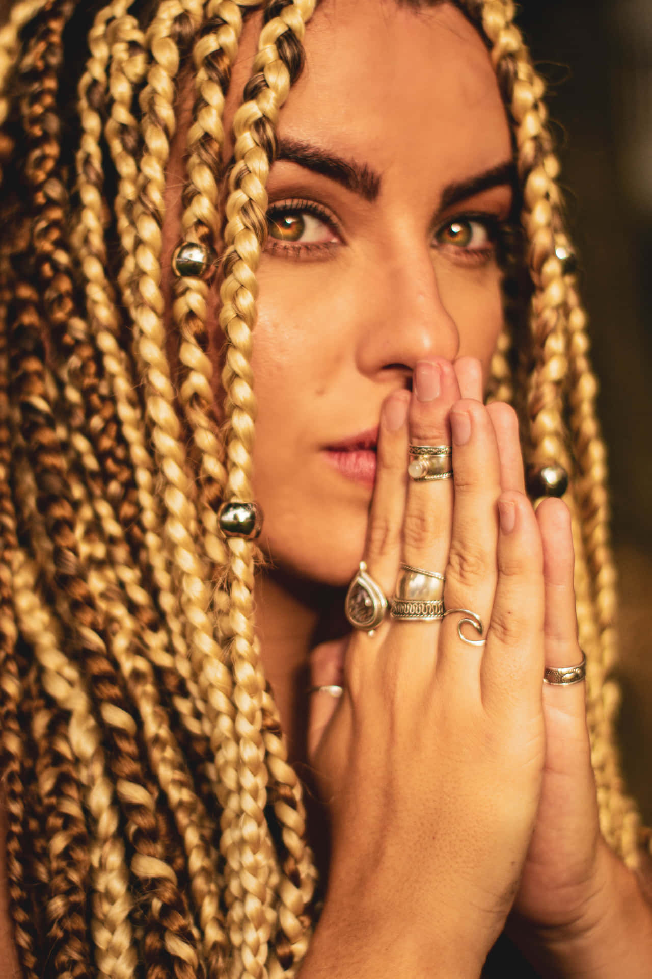 A Woman With Braids And Rings On Her Hands