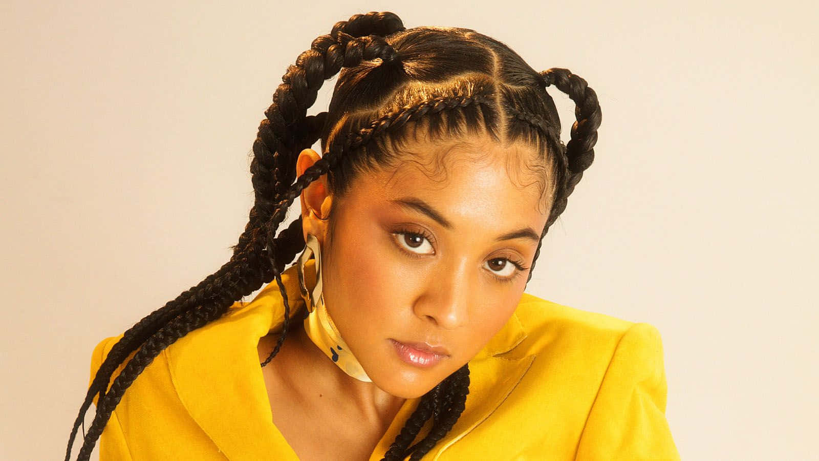 A Woman In A Yellow Jacket With Braids