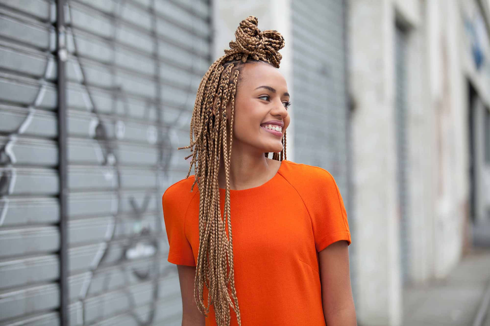 A Young Woman Wearing An Orange Dress And Braids