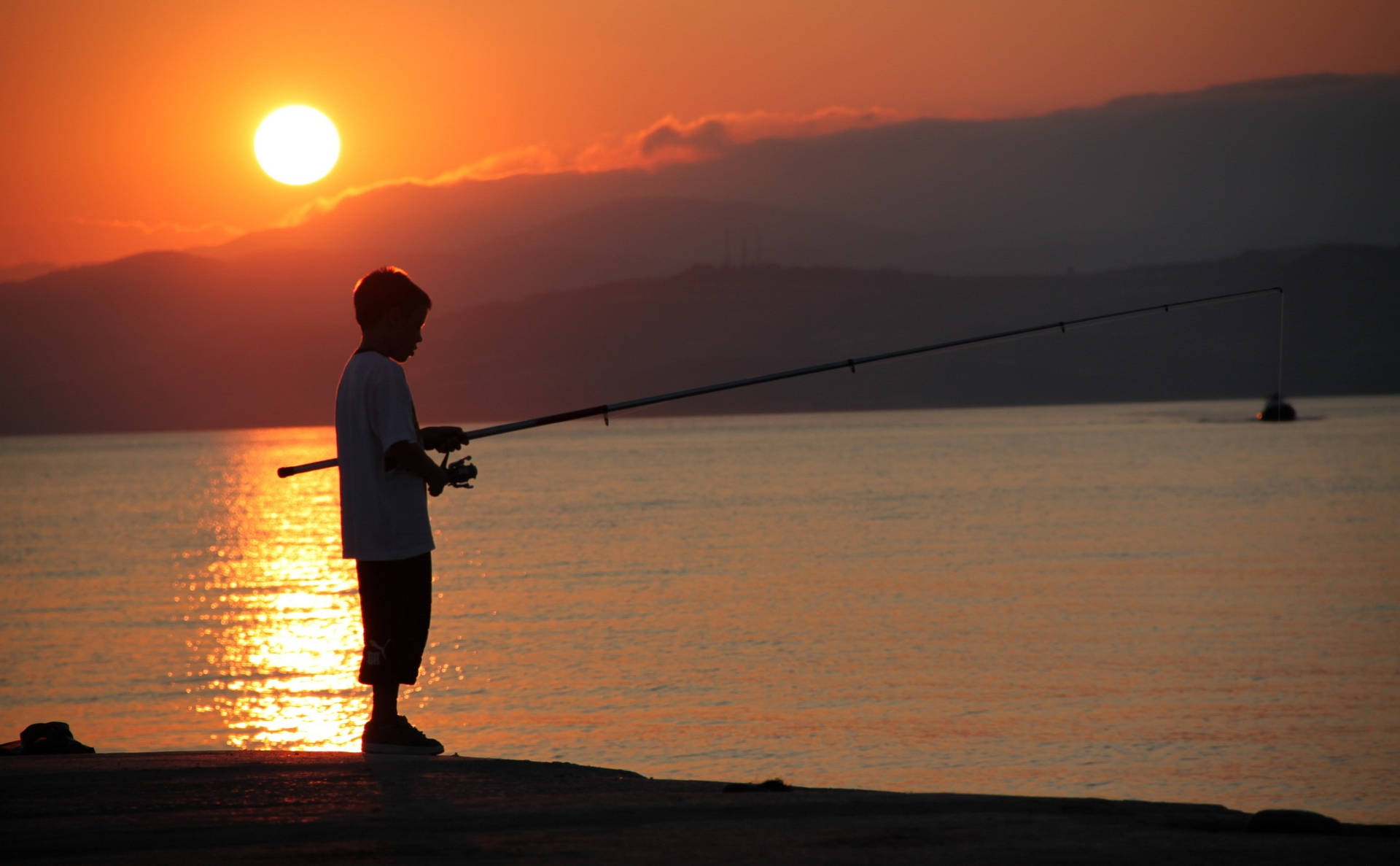 Boy Fishing During Sunset