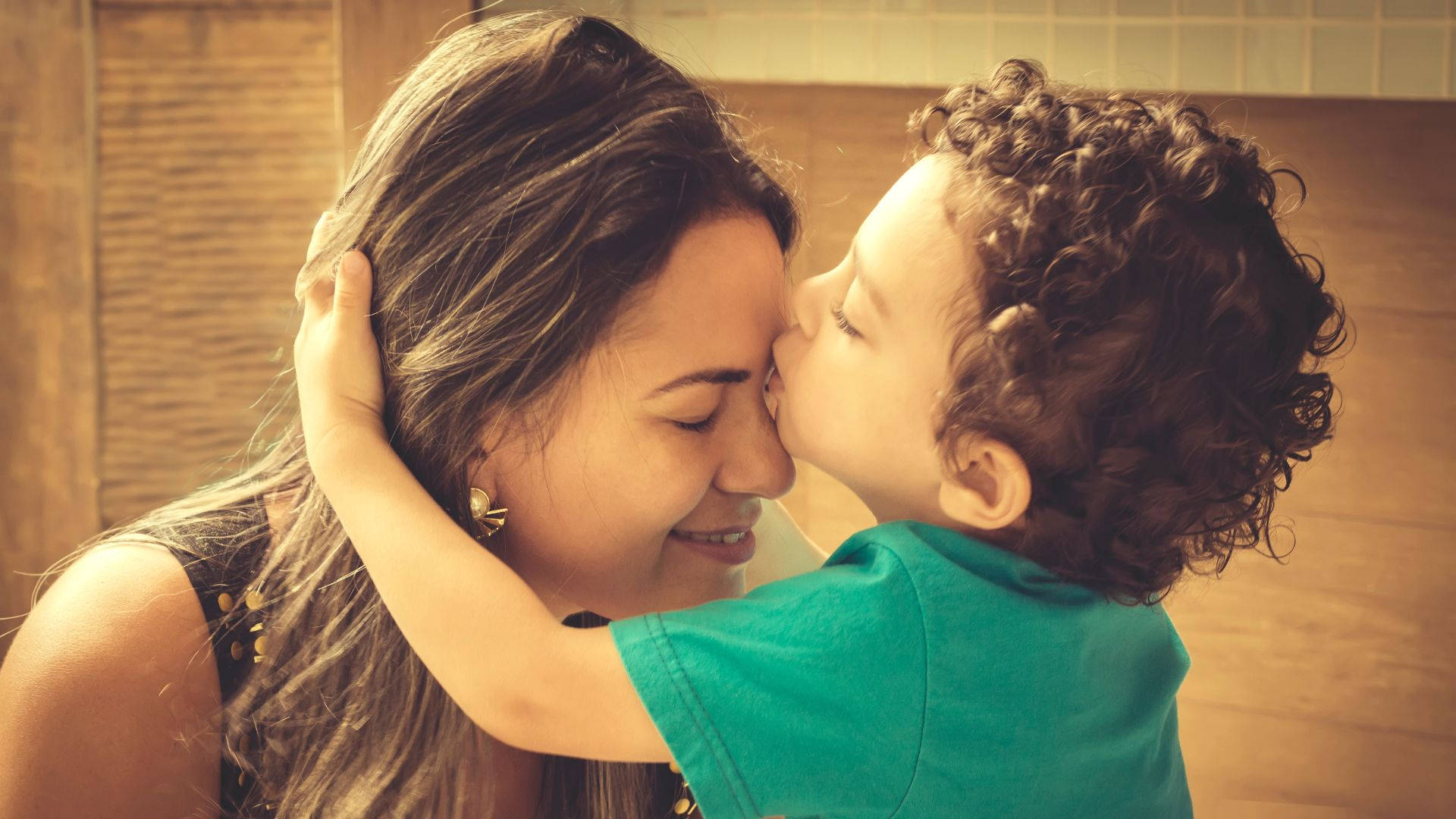 Tender Moments: Boy Kissing His Mom Wallpaper