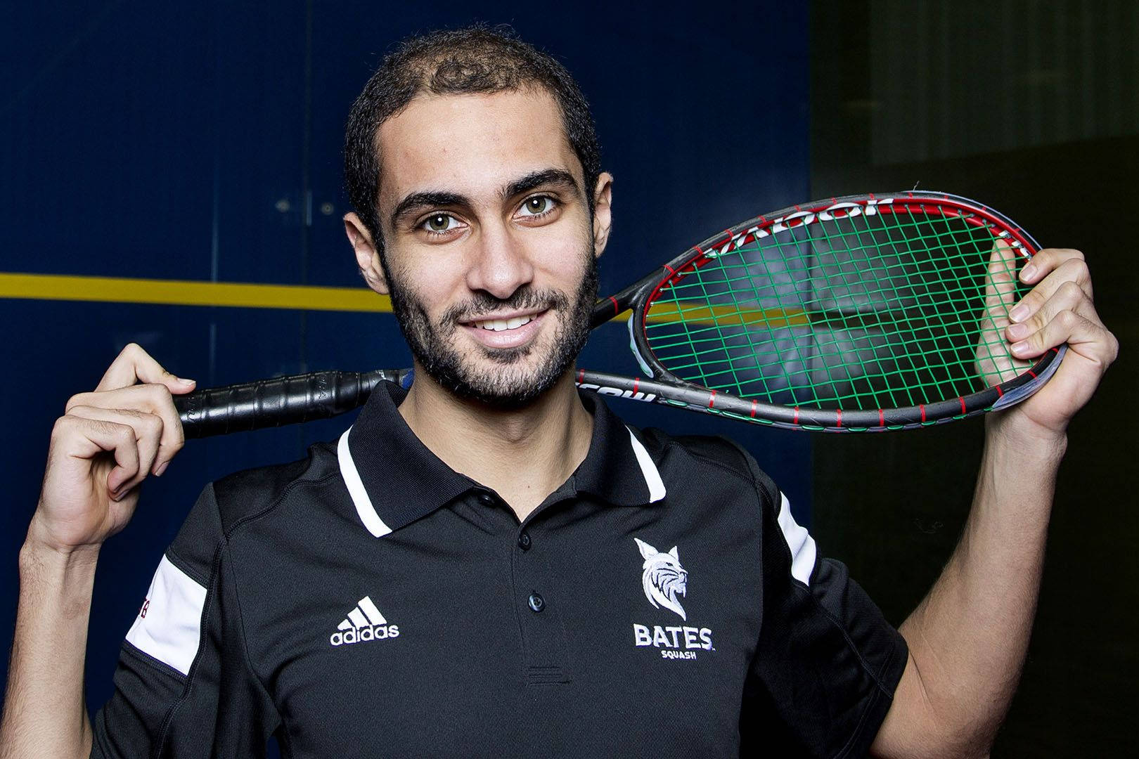 Boy Posing With Squash Racket Background