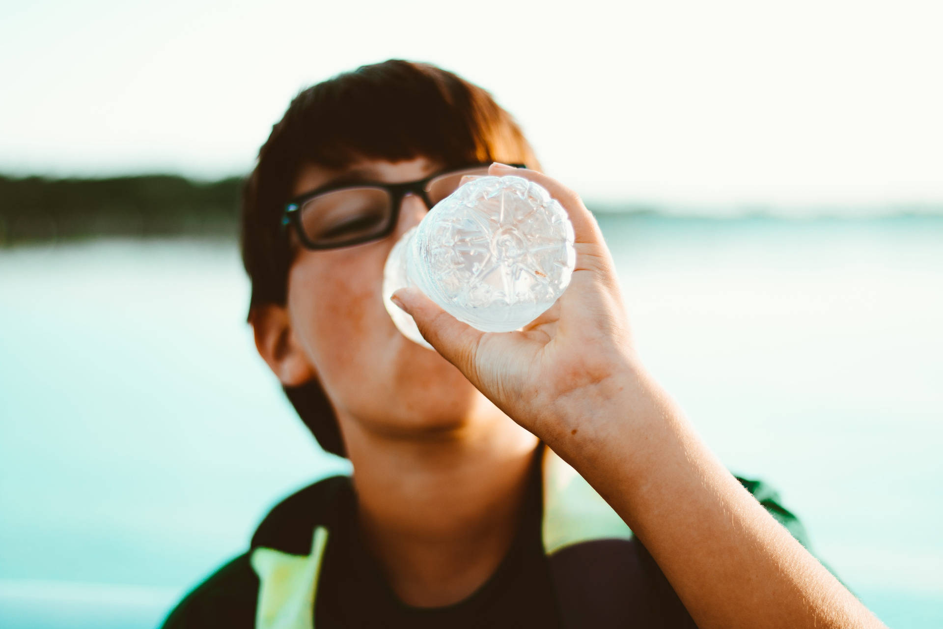 Boy With Glasses Drinking Water Wallpaper
