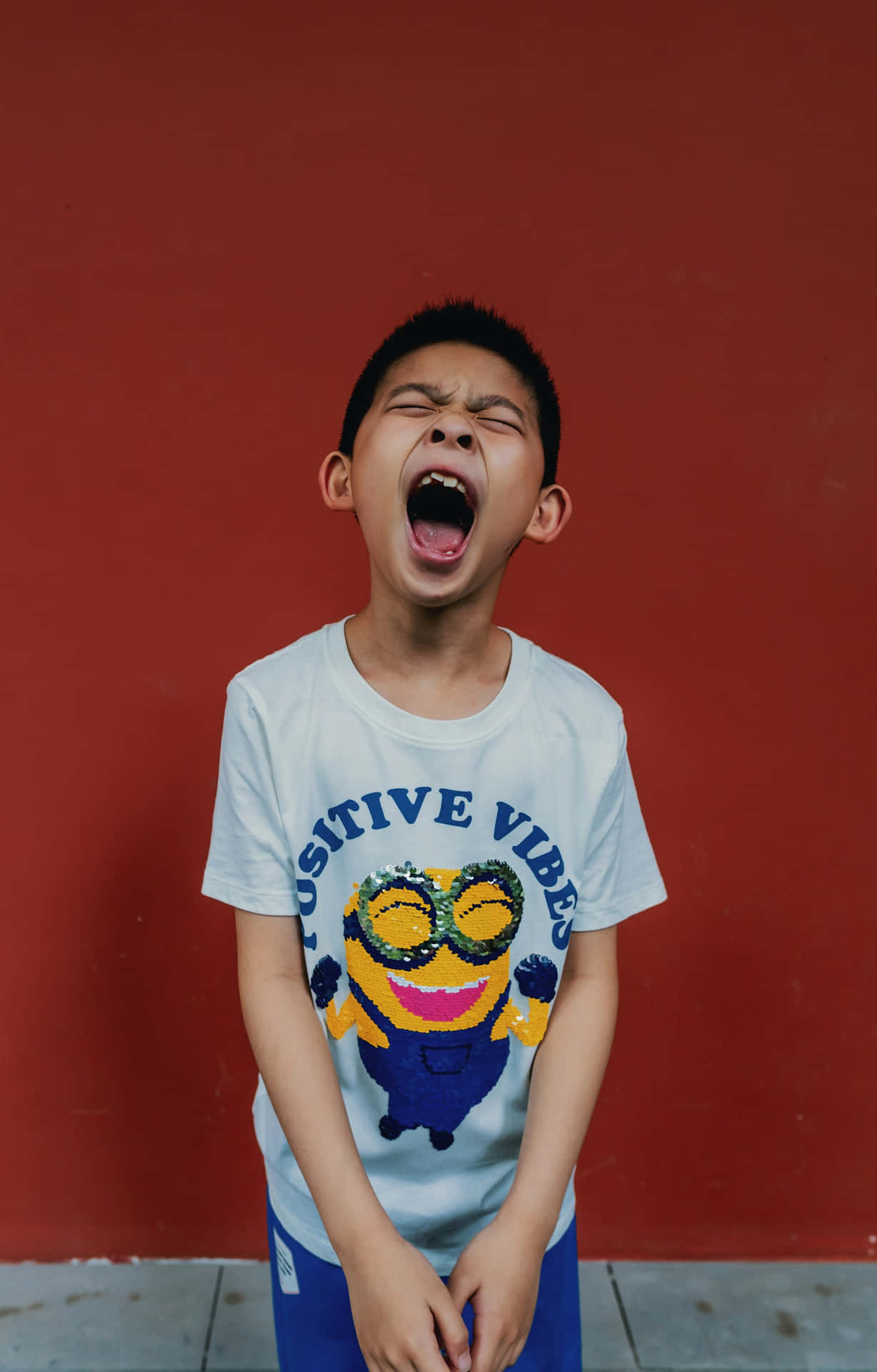 Boy Yawning Against Red Wall Wallpaper