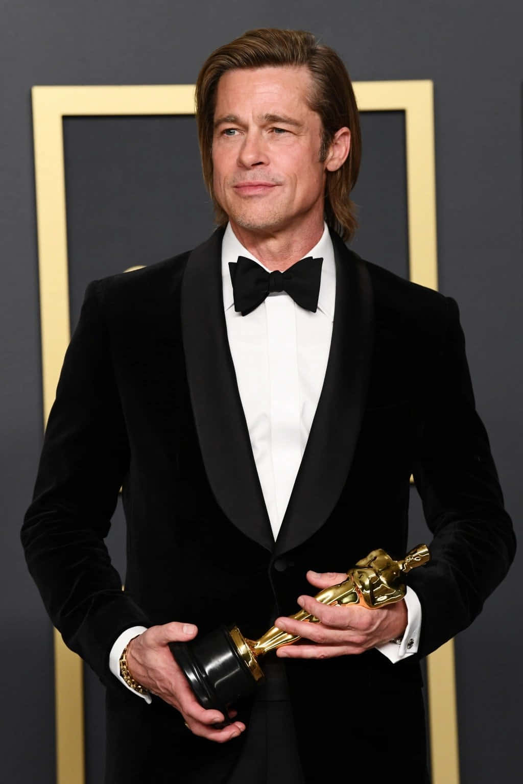 Brad Pitt wears a striped shirt while looking dapper