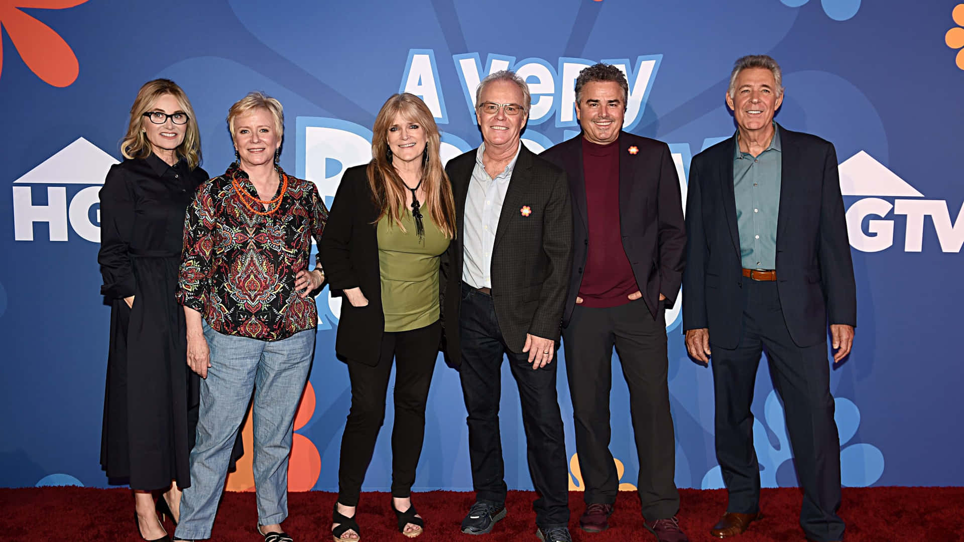 A Group Of People Standing On A Red Carpet Wallpaper