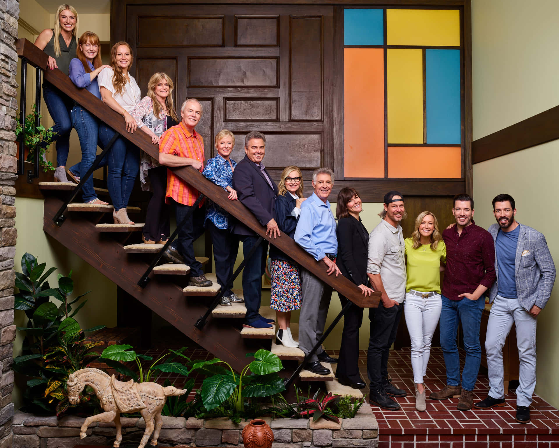 A Group Of People Standing On Stairs In A House Wallpaper