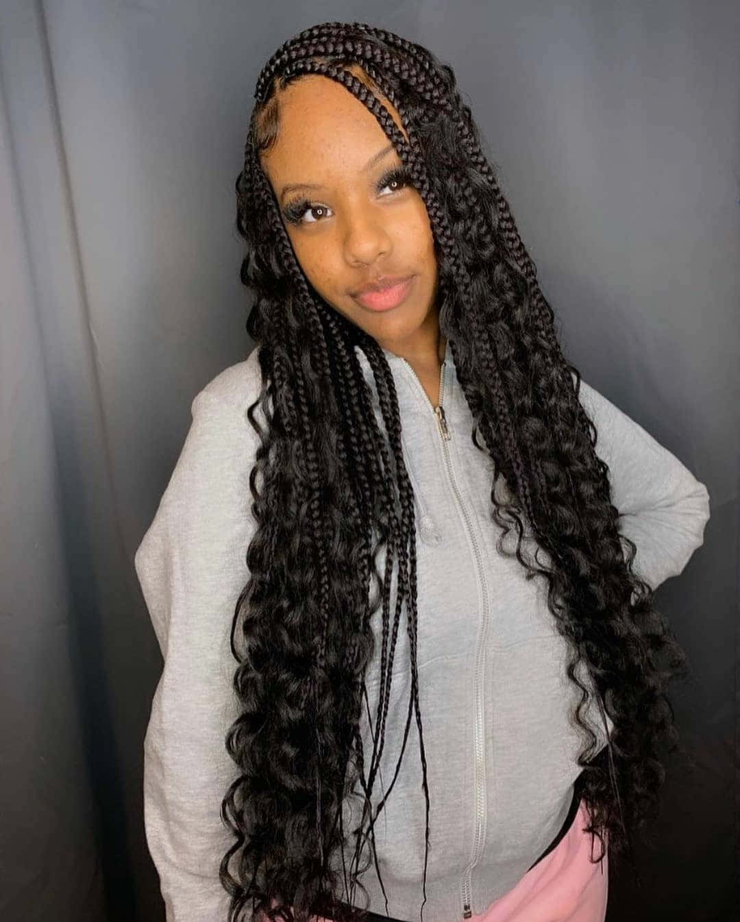 A Woman With Long Braids Posing For A Photo