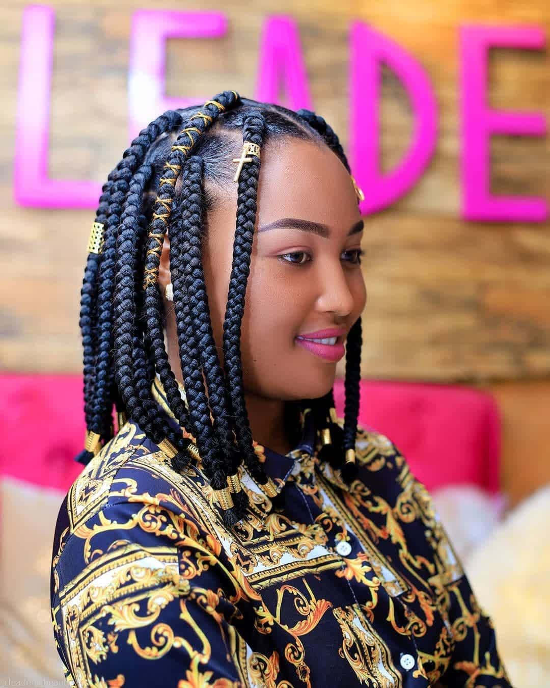 A Woman With Braids Sitting On A Couch