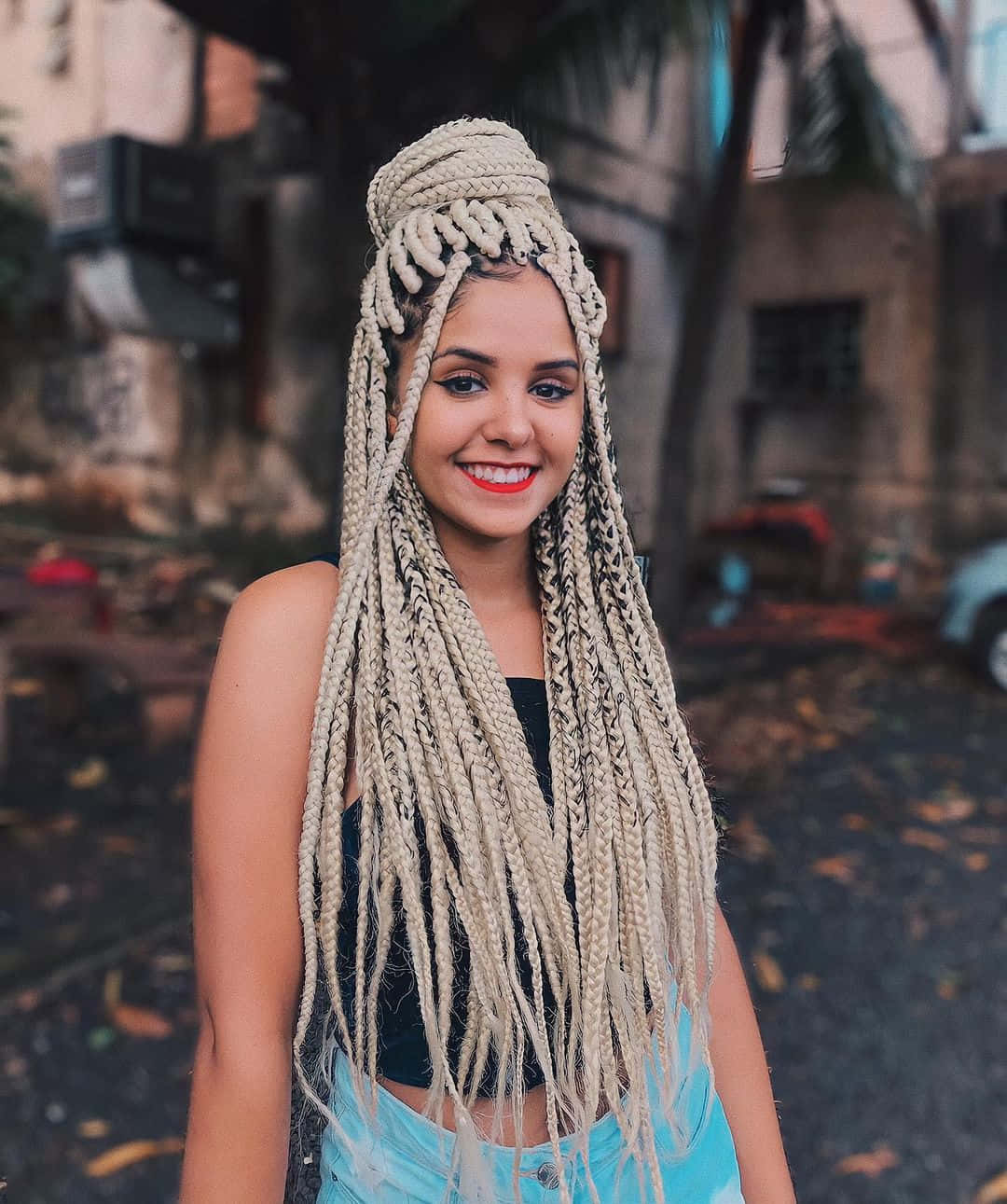 A Woman With Long Braids Posing For A Photo