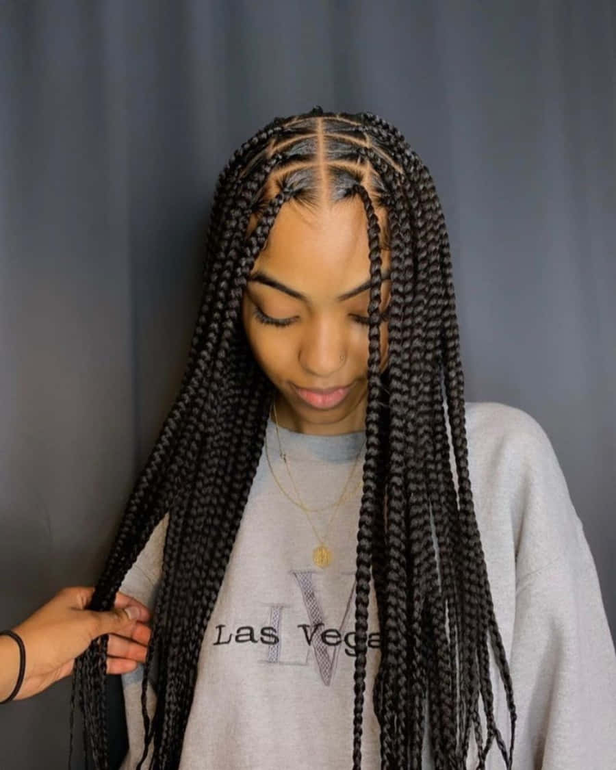 A Woman With Long Braids Is Getting Her Hair Braided