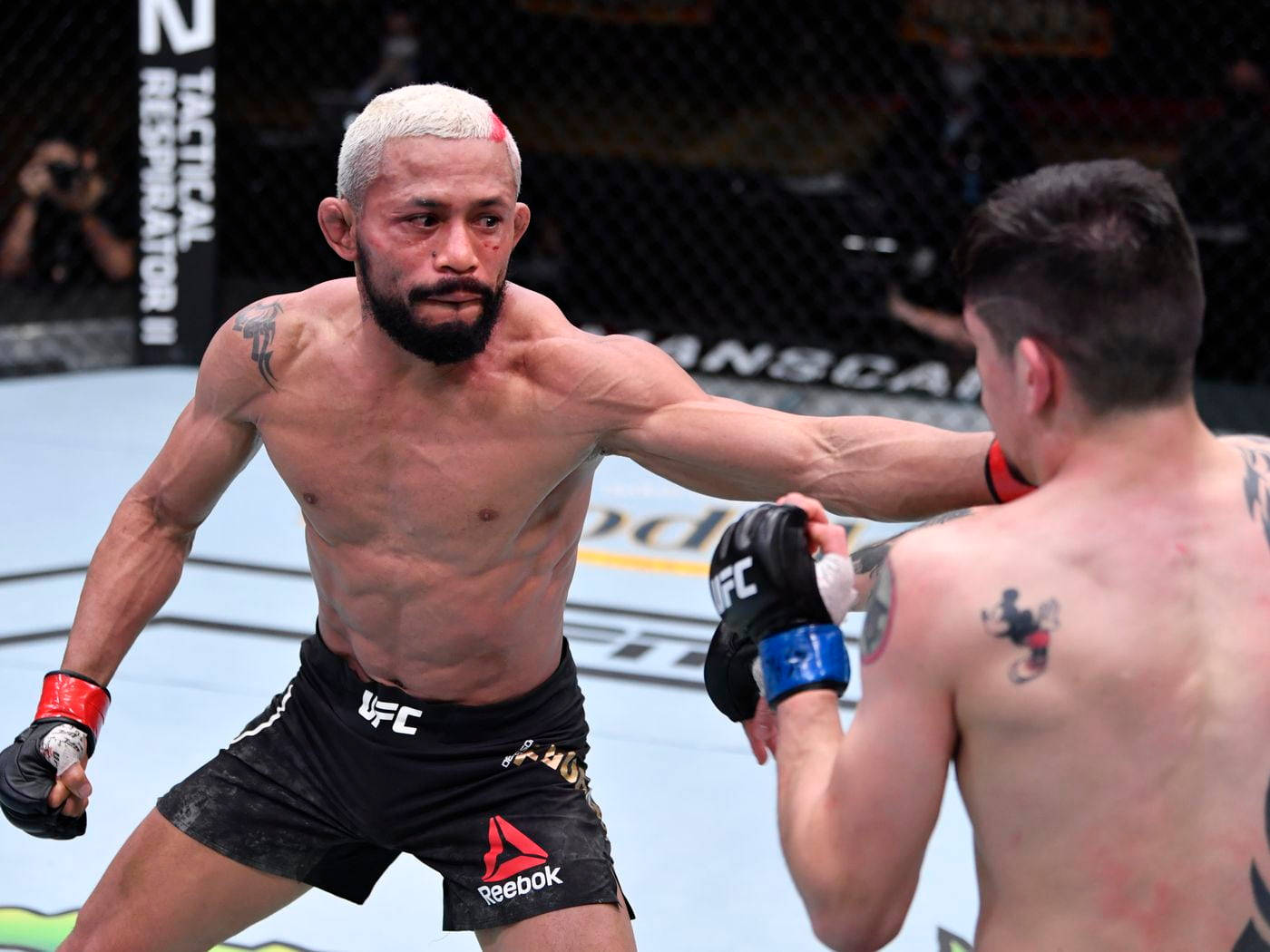 Brandon Moreno deflecting a hit from Deiveson Figueiredo in an intense UFC match. Wallpaper