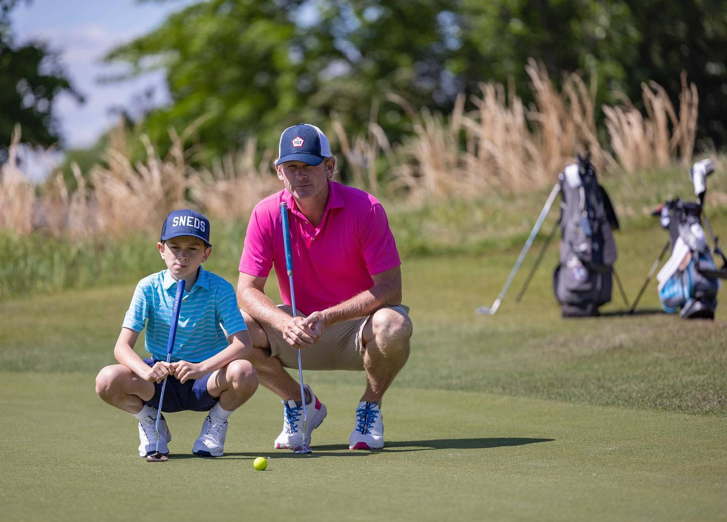 Brandt Snedeker og søn spiller golf på teppegulvet. Wallpaper
