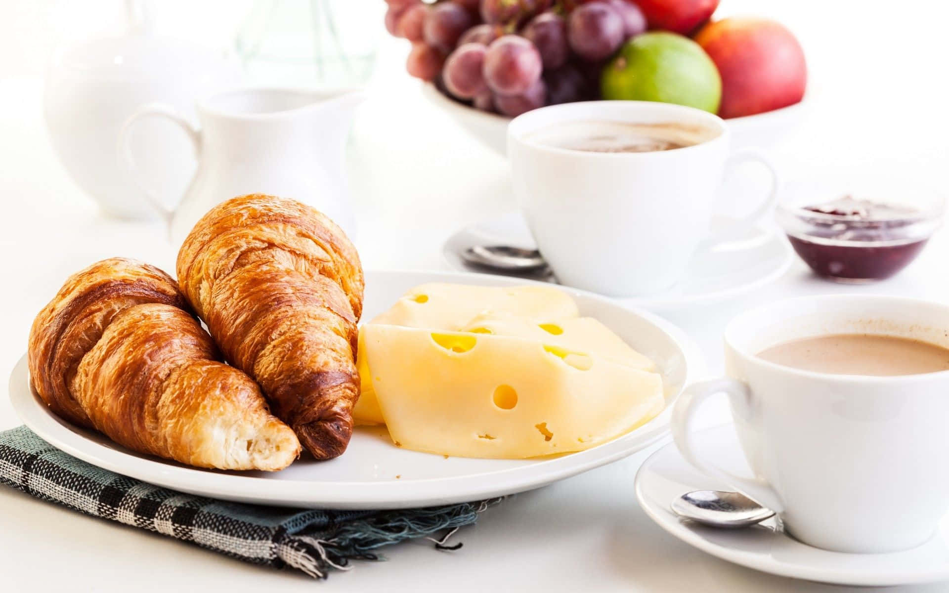 A delectable morning spread: fruits, coffee, and croissant