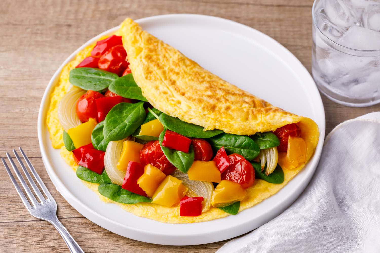 Omelet With Vegetables And A Fork On A Plate