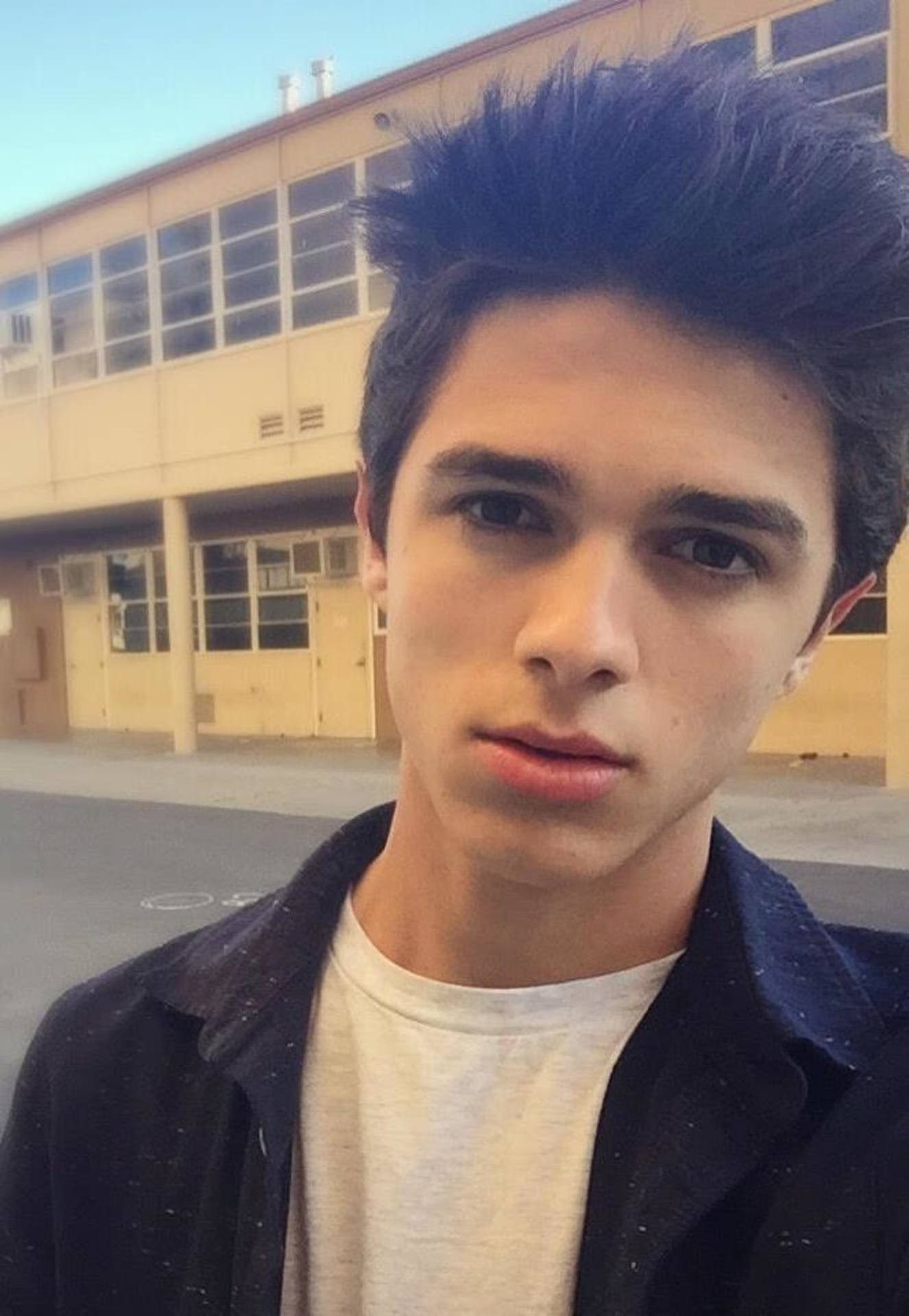 Vibrant photo of Brent Rivera leaning against a building. Wallpaper