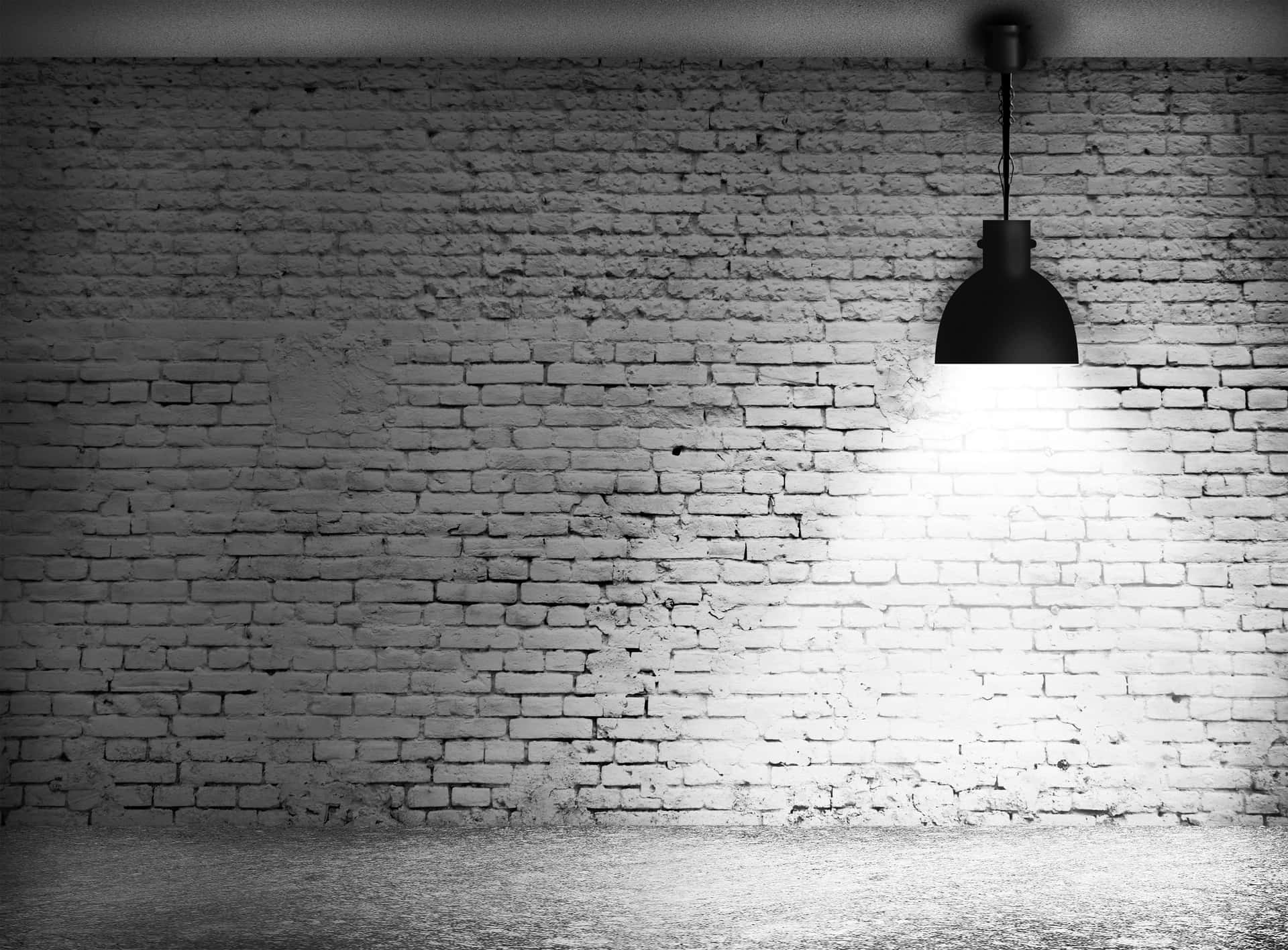 A Lamp Is Hanging In An Empty Room With A Brick Wall