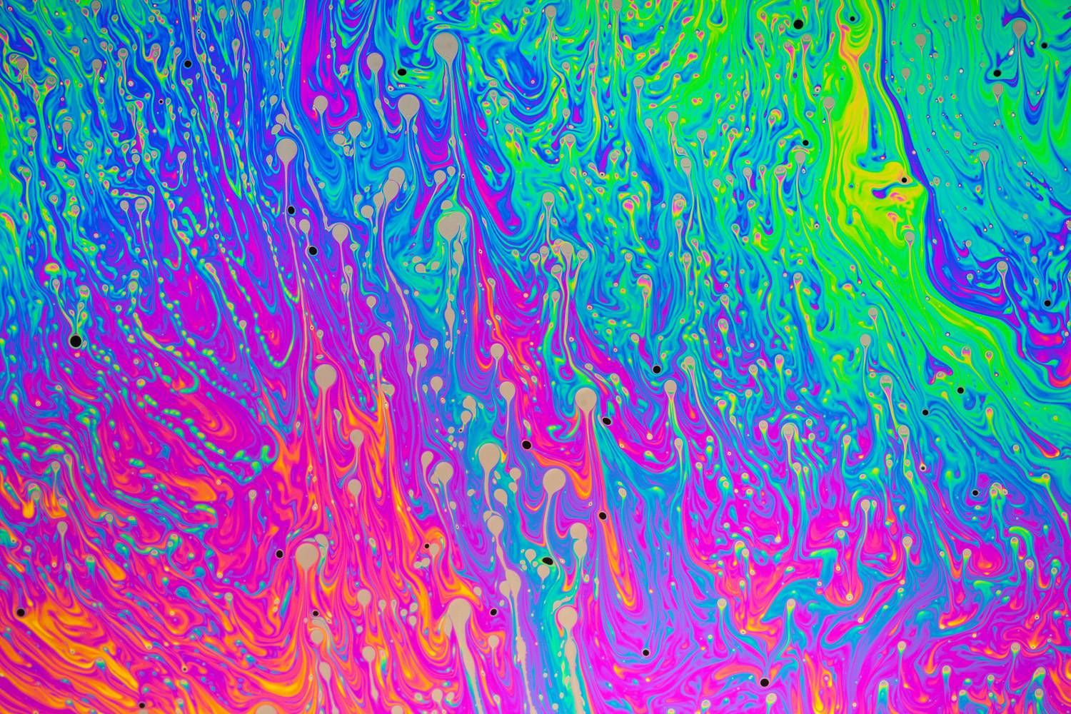 Bright colors psychedelic paint mixture wallpaper.