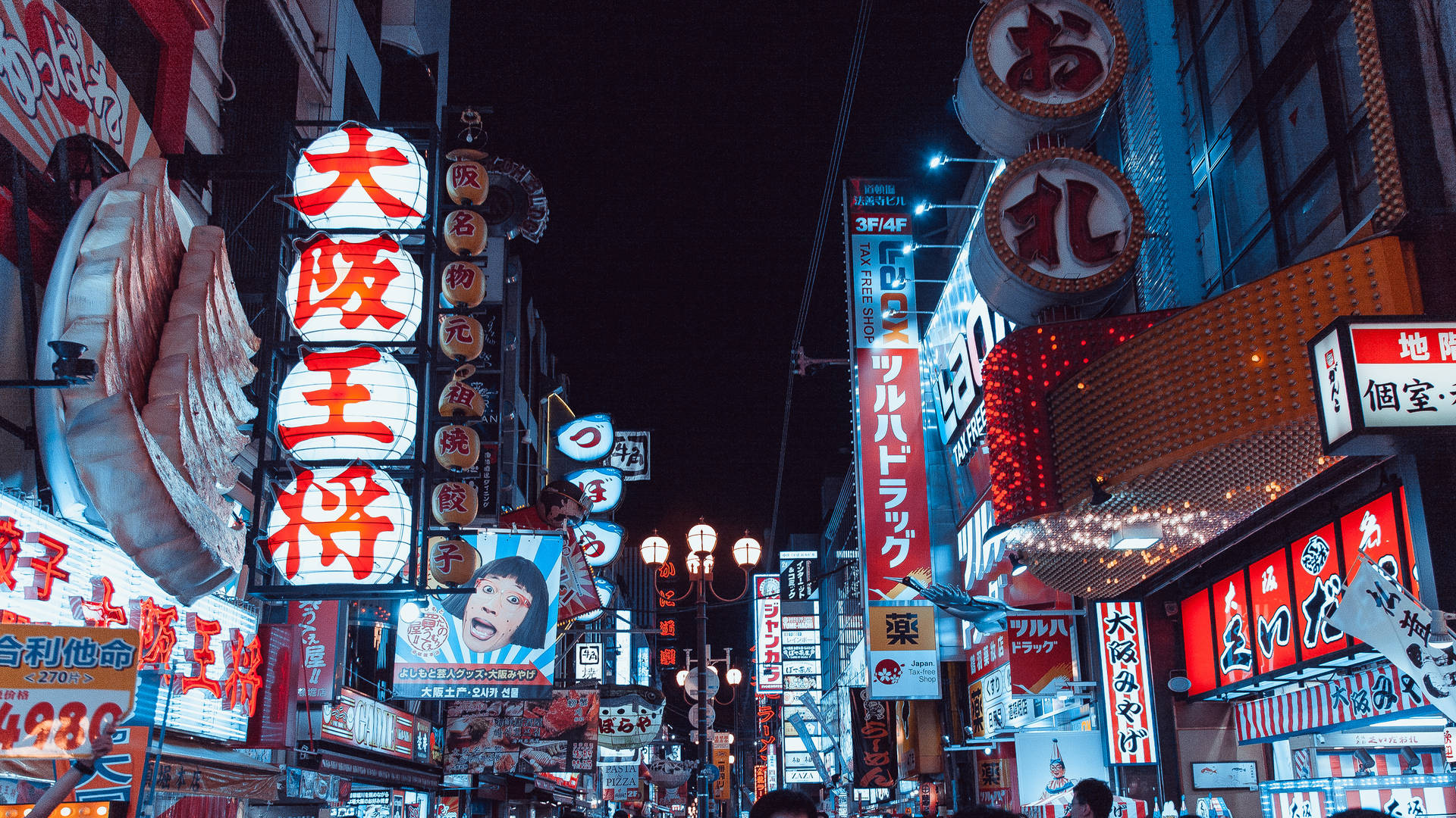 Bright shop signs light up the nighttime street in Tokyo, Japan Wallpaper