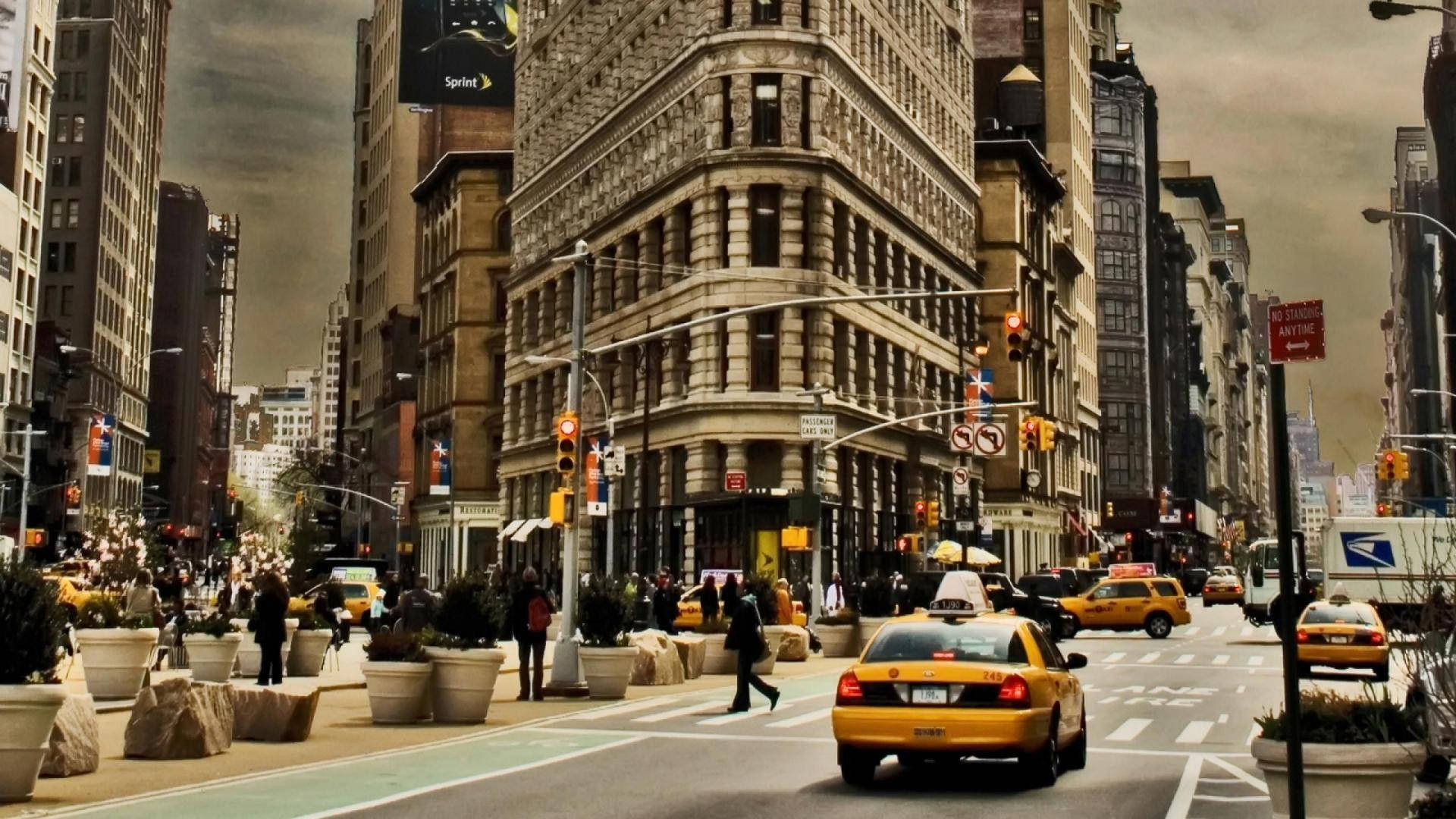 A City Street With Tall Buildings And Taxis Wallpaper