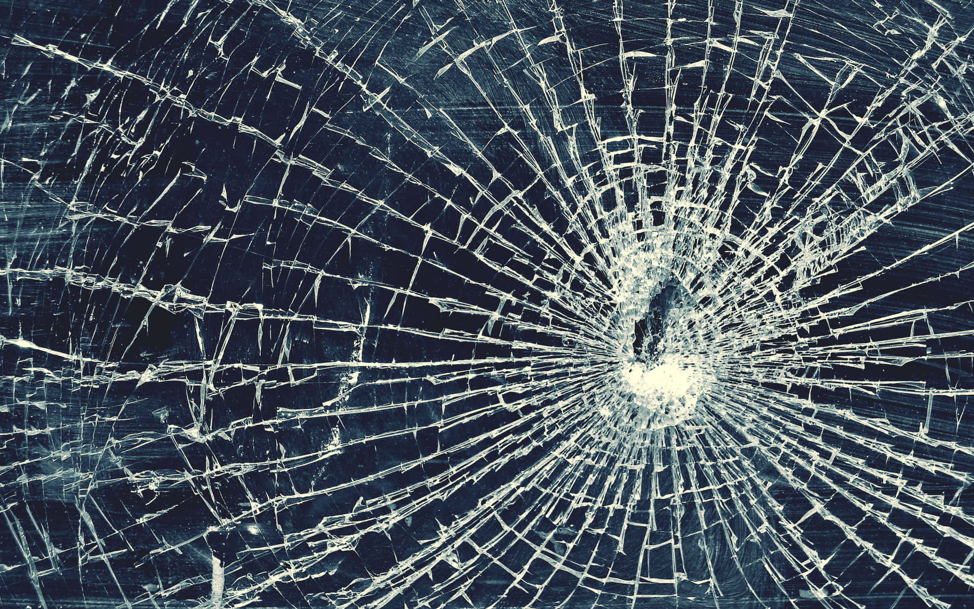 Shattered glass displaying its intricate pattern against a dark backdrop