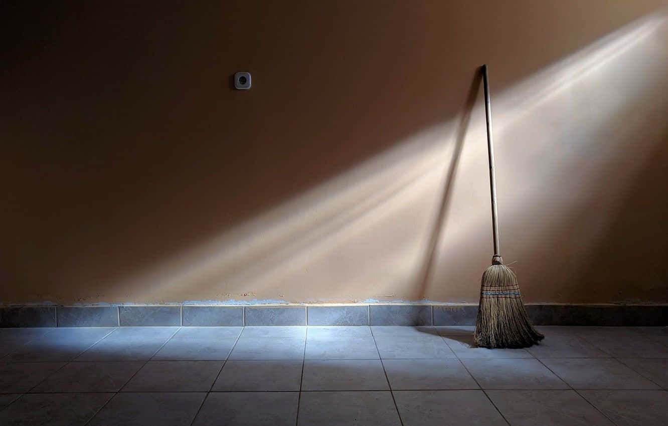 A Broom Leaning Against A Wall In A Room