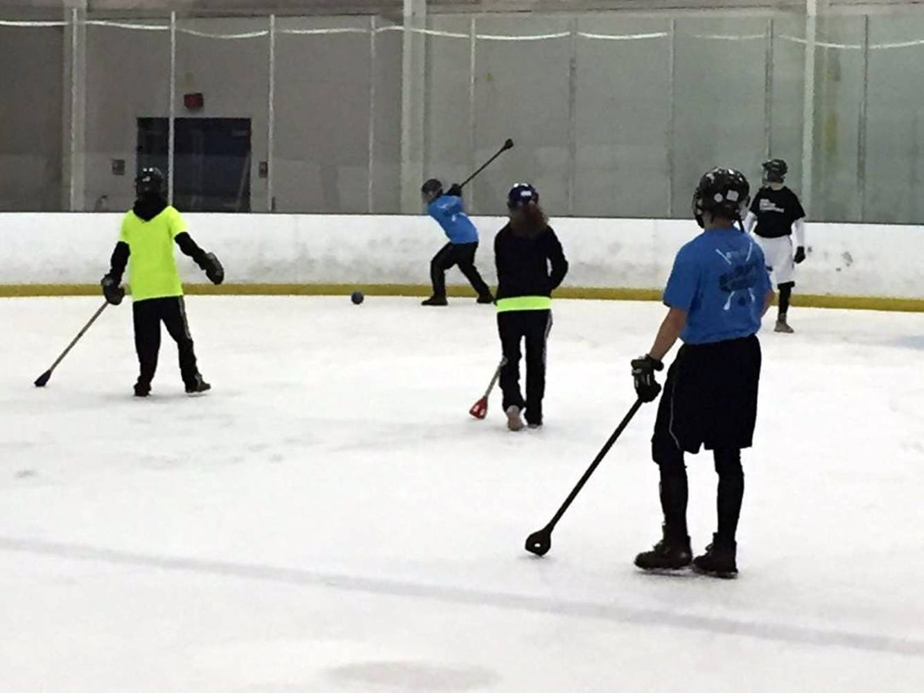 Energetic Young Players Engaged in a Broomball Game Wallpaper