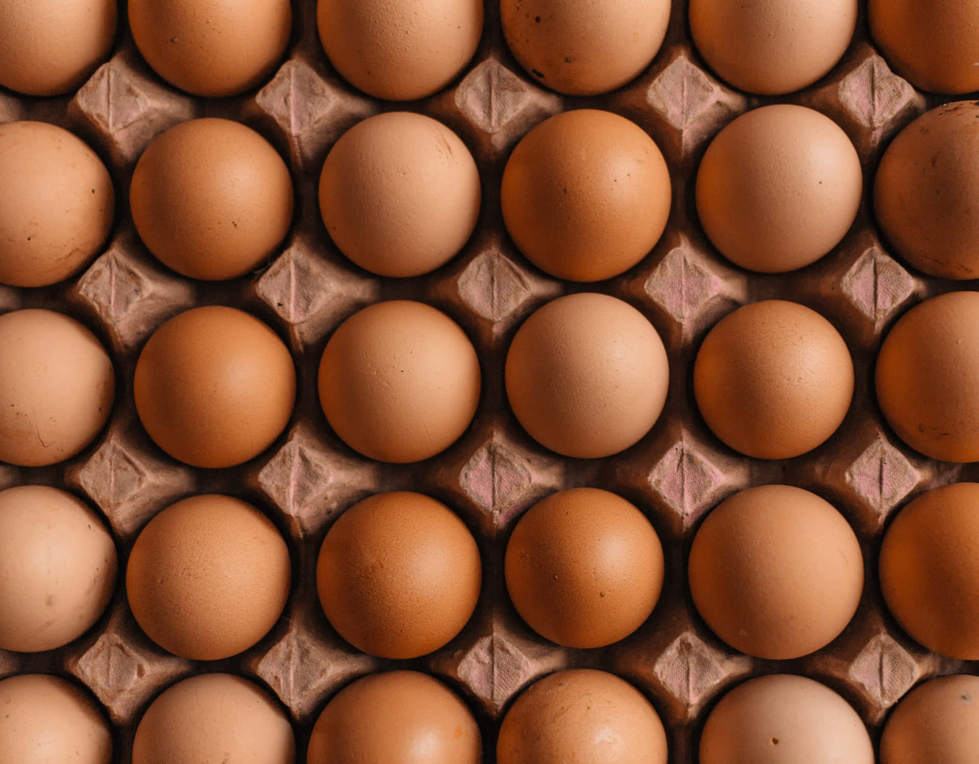 A carton of fresh brown eggs on a rustic wooden table Wallpaper