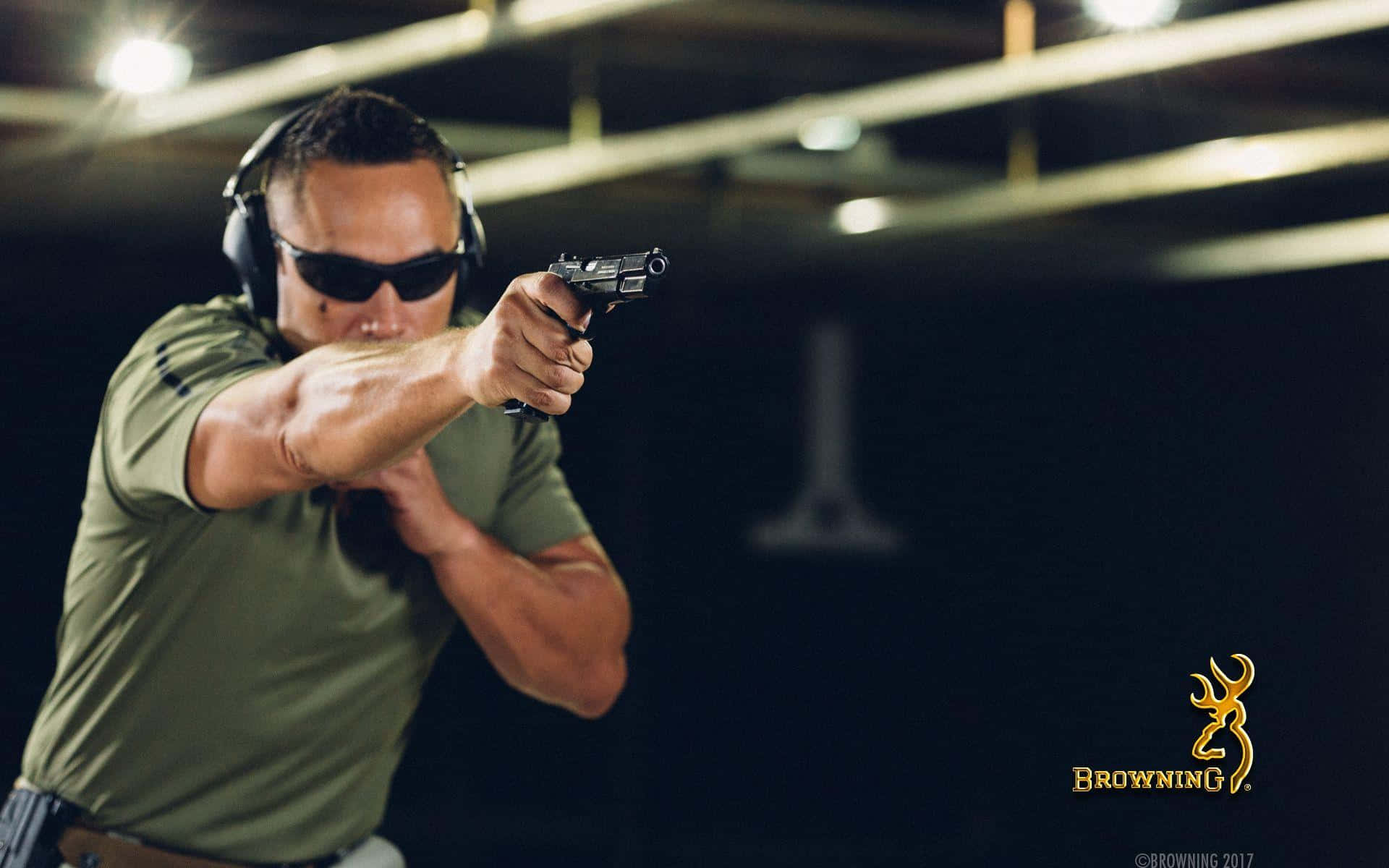 En mand iført solbriller holder et gevær. Wallpaper