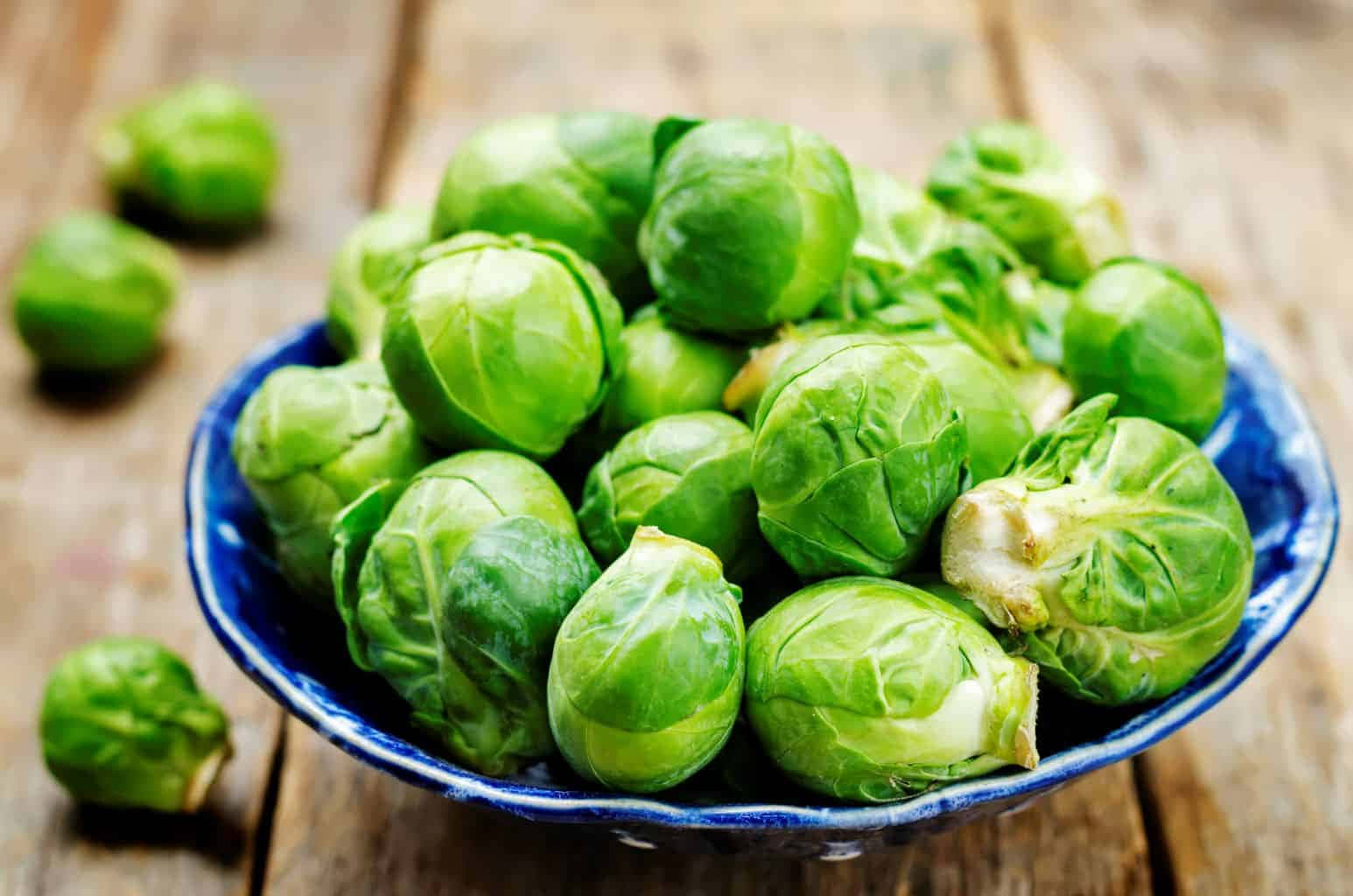 Brussels Sprouts In A Blue Bowl On A Wooden Table