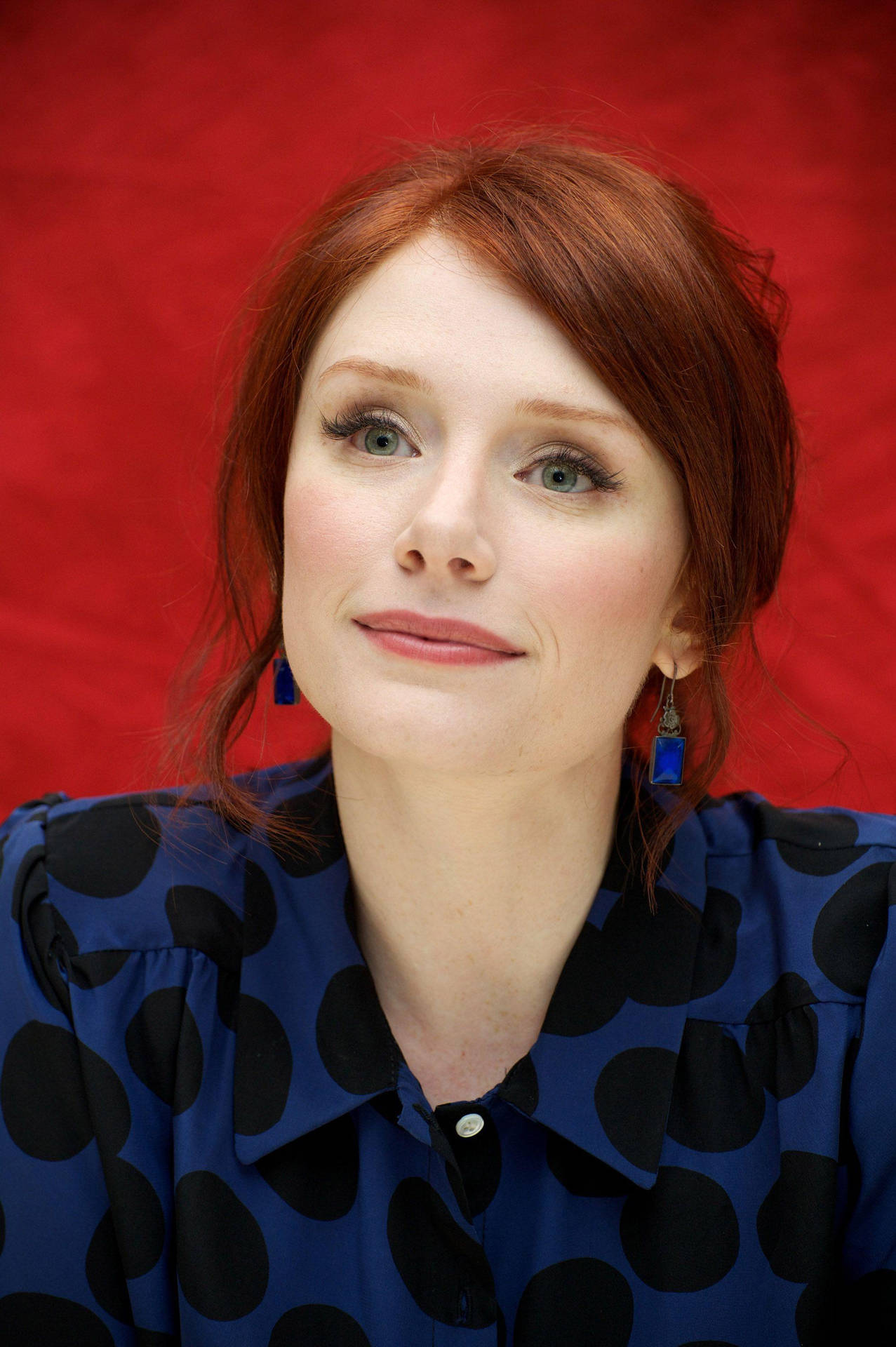Bryce Dallas Howard In Blue Outfit On Red Background Wallpaper