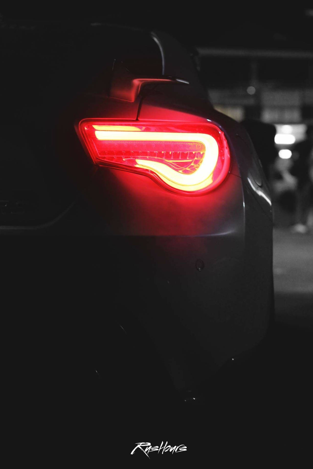 A Car With A Red Tail Light In The Dark Wallpaper
