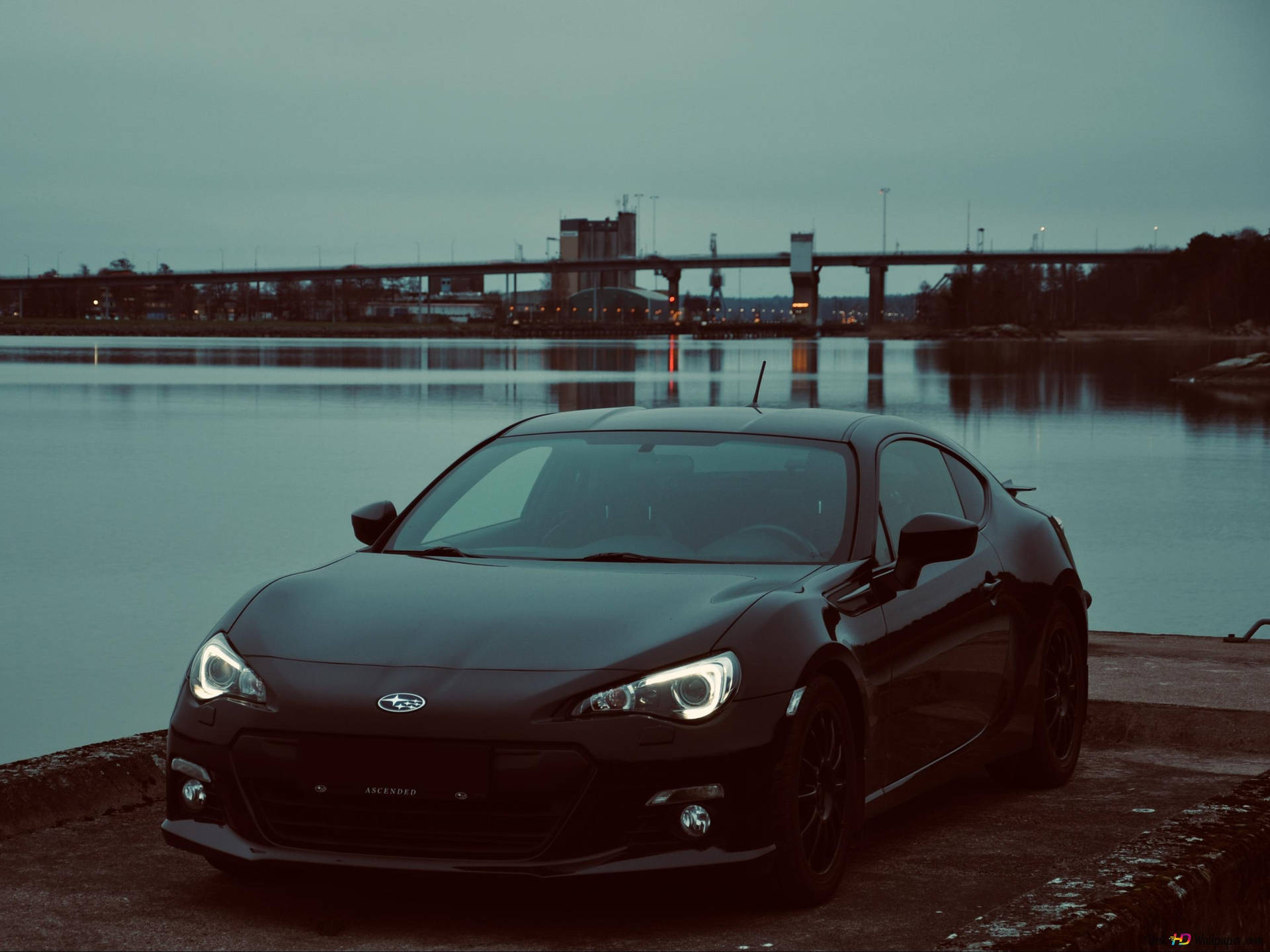 A Black Car Parked Near A Body Of Water Wallpaper
