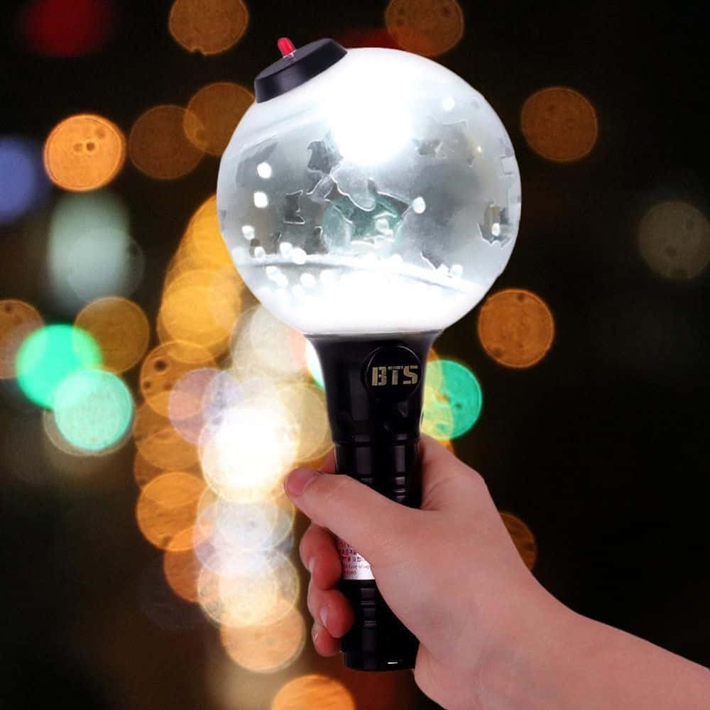 Fans proudly holding BTS Army Bombs during a concert Wallpaper