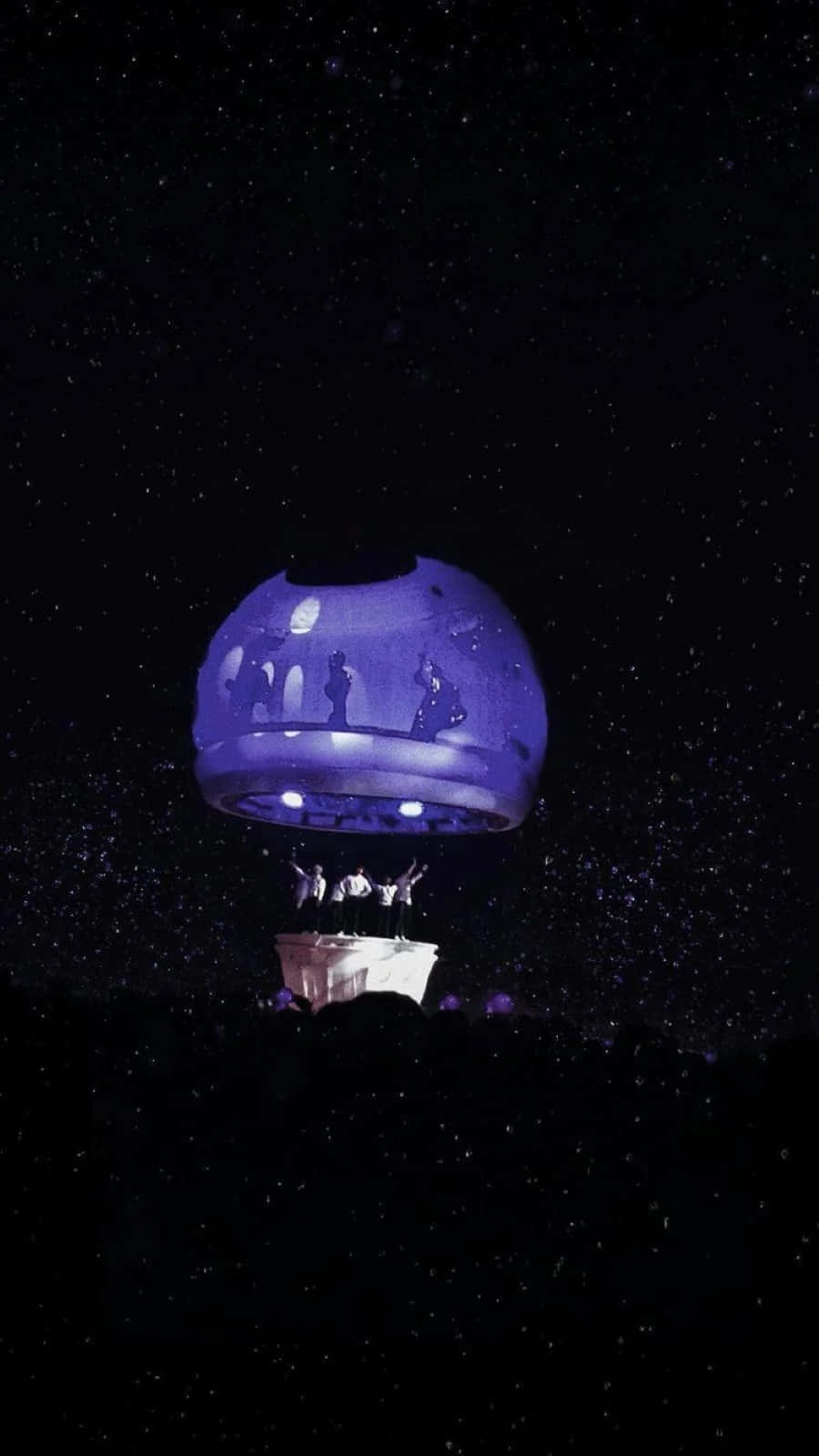 A BTS Army Bomb illuminating the night sky at a concert Wallpaper